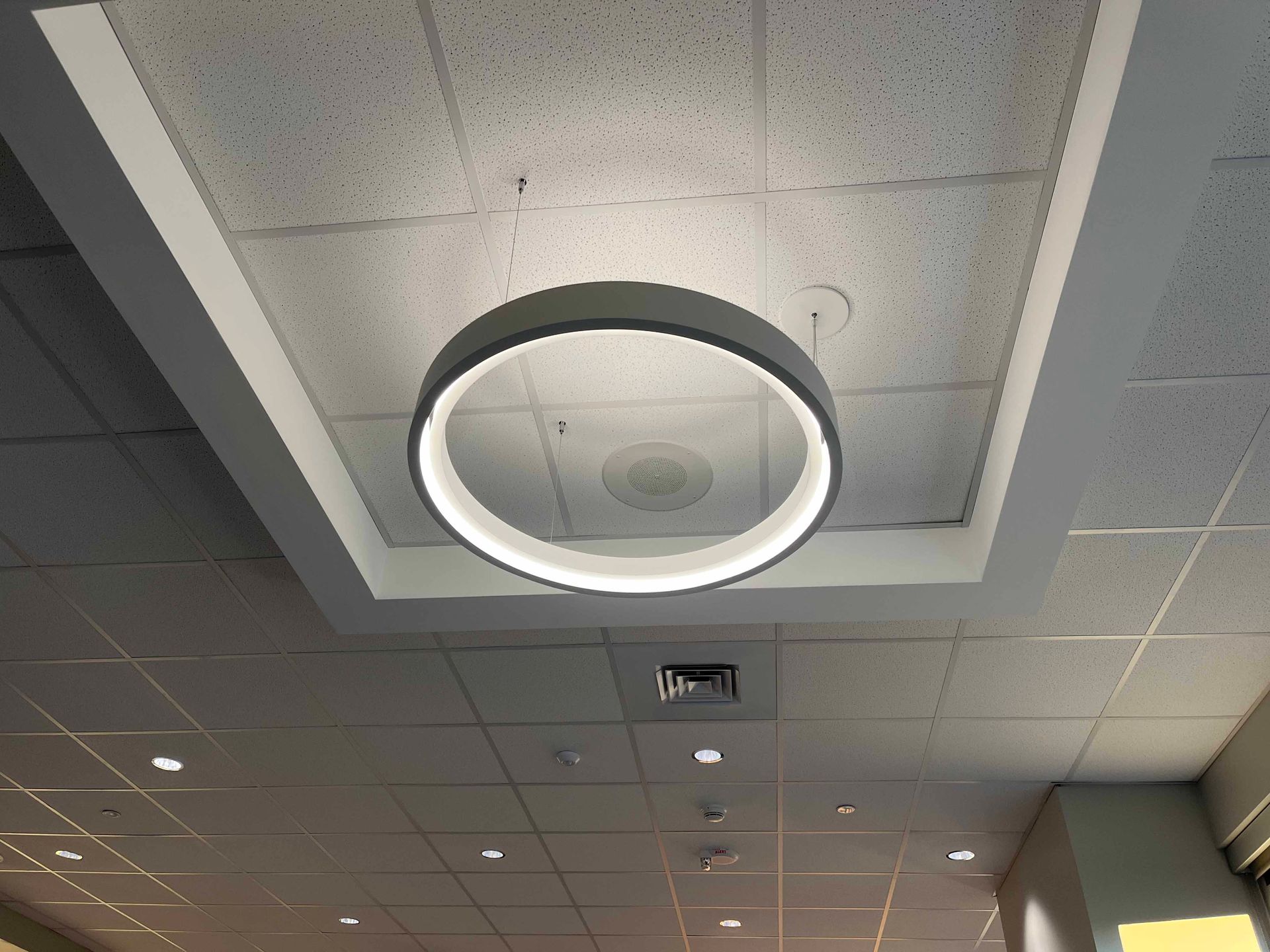 A ceiling with a circular light hanging from it