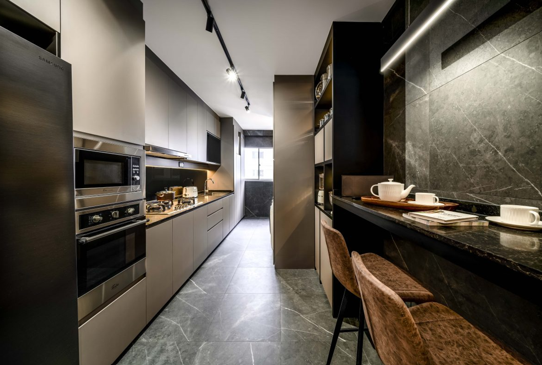 A kitchen with a long counter and stools and a refrigerator.