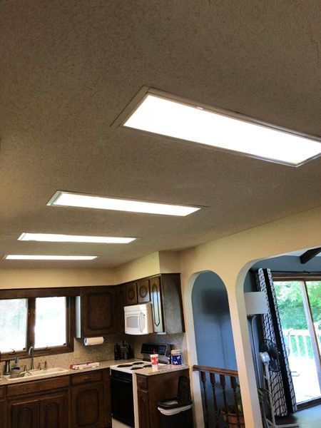 Kitchen with recessed fluorescent lighting and wood cabinets.