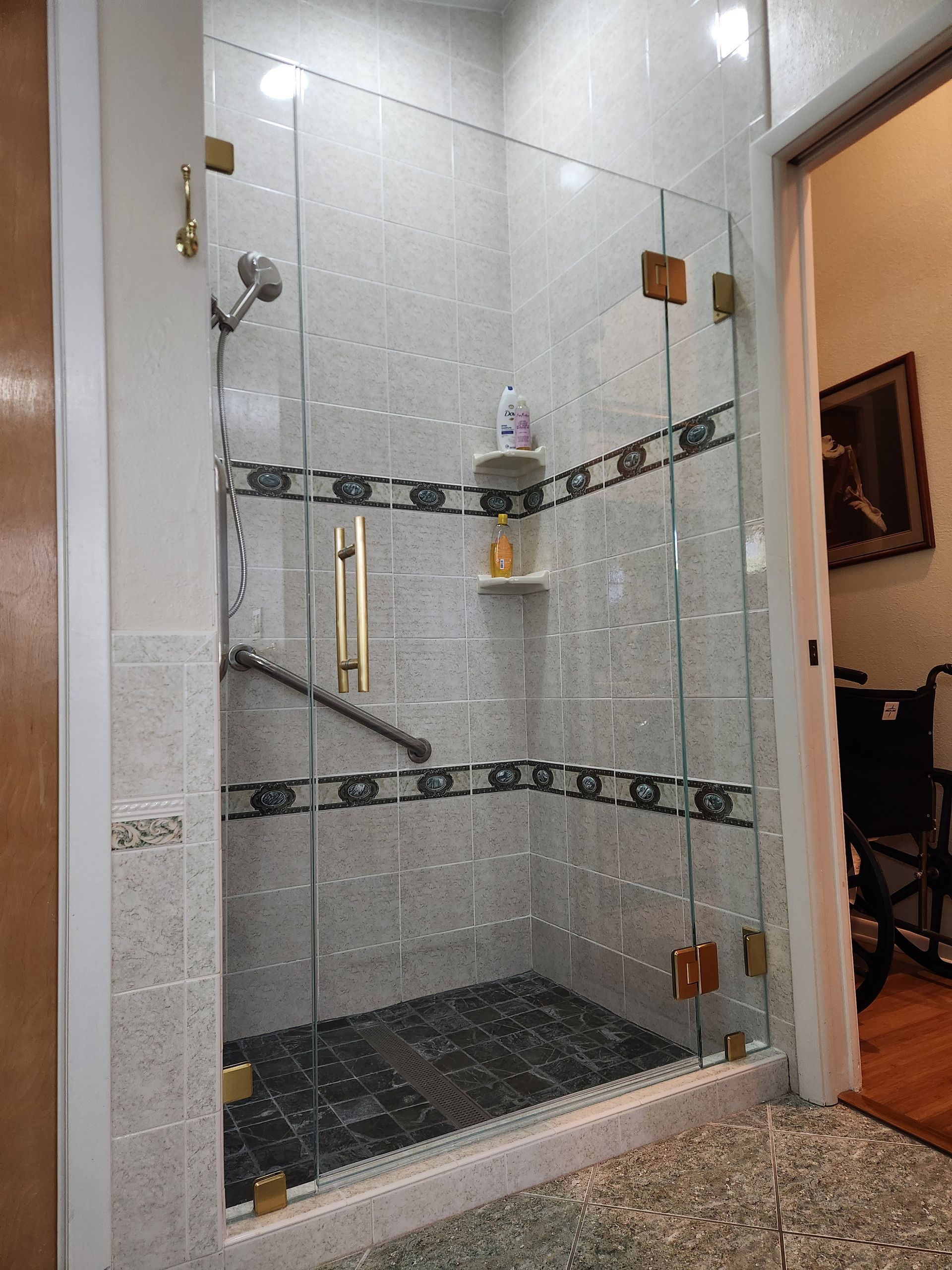 a bathroom with a walk in shower with a glass door .