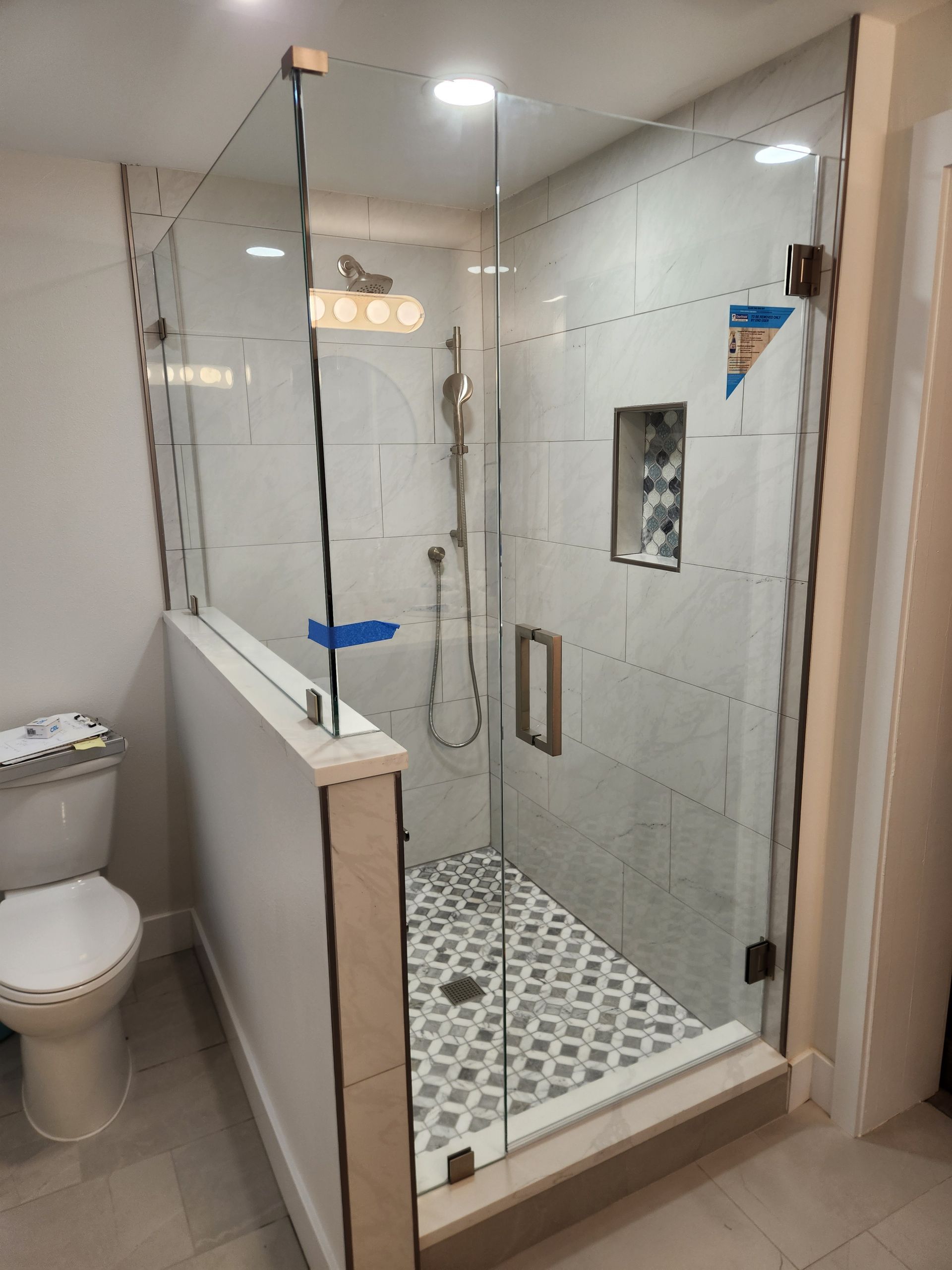 A bathroom with a walk in shower and a toilet.