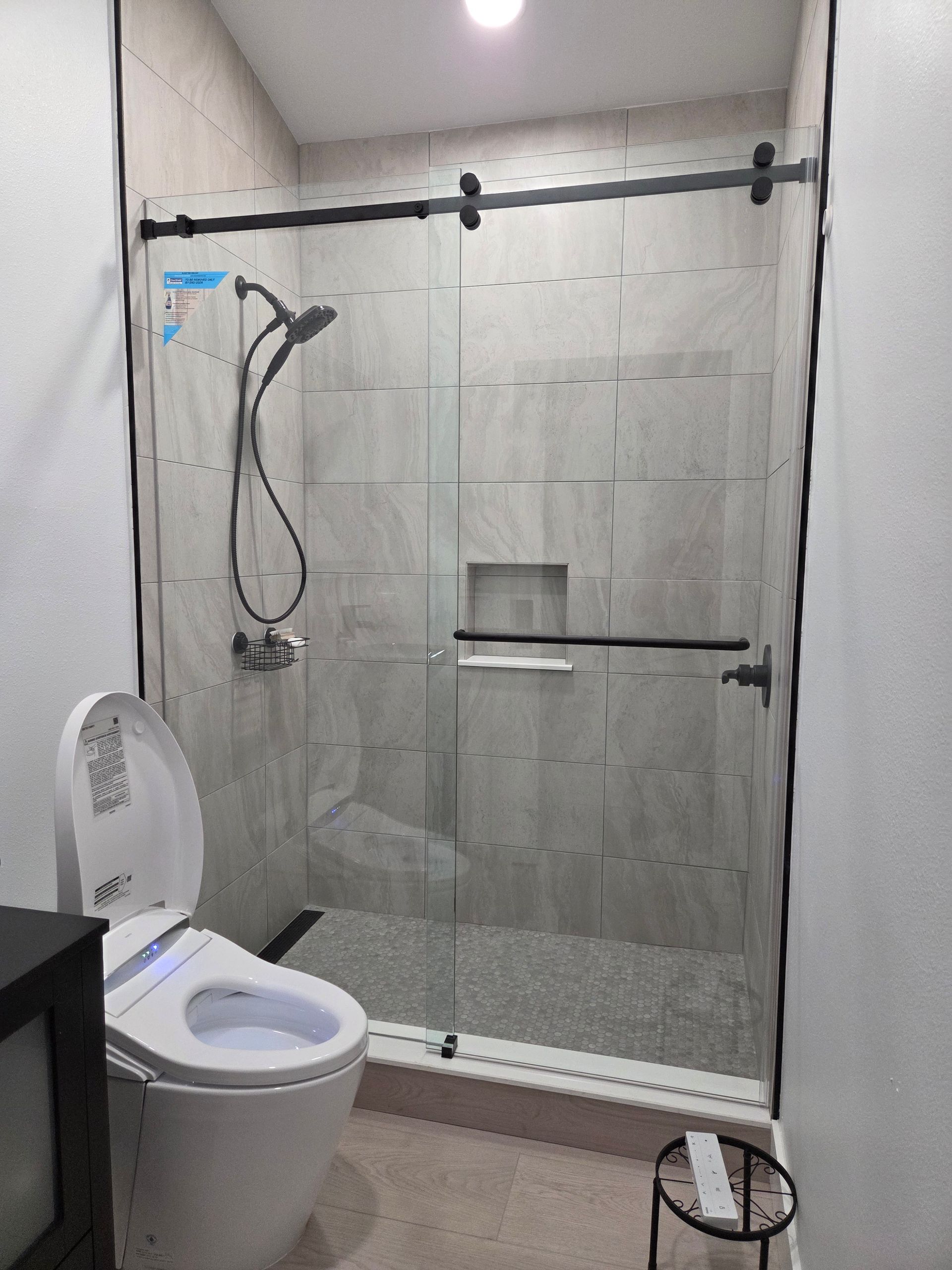 Bathroom with a glass shower door and a smart toilet.