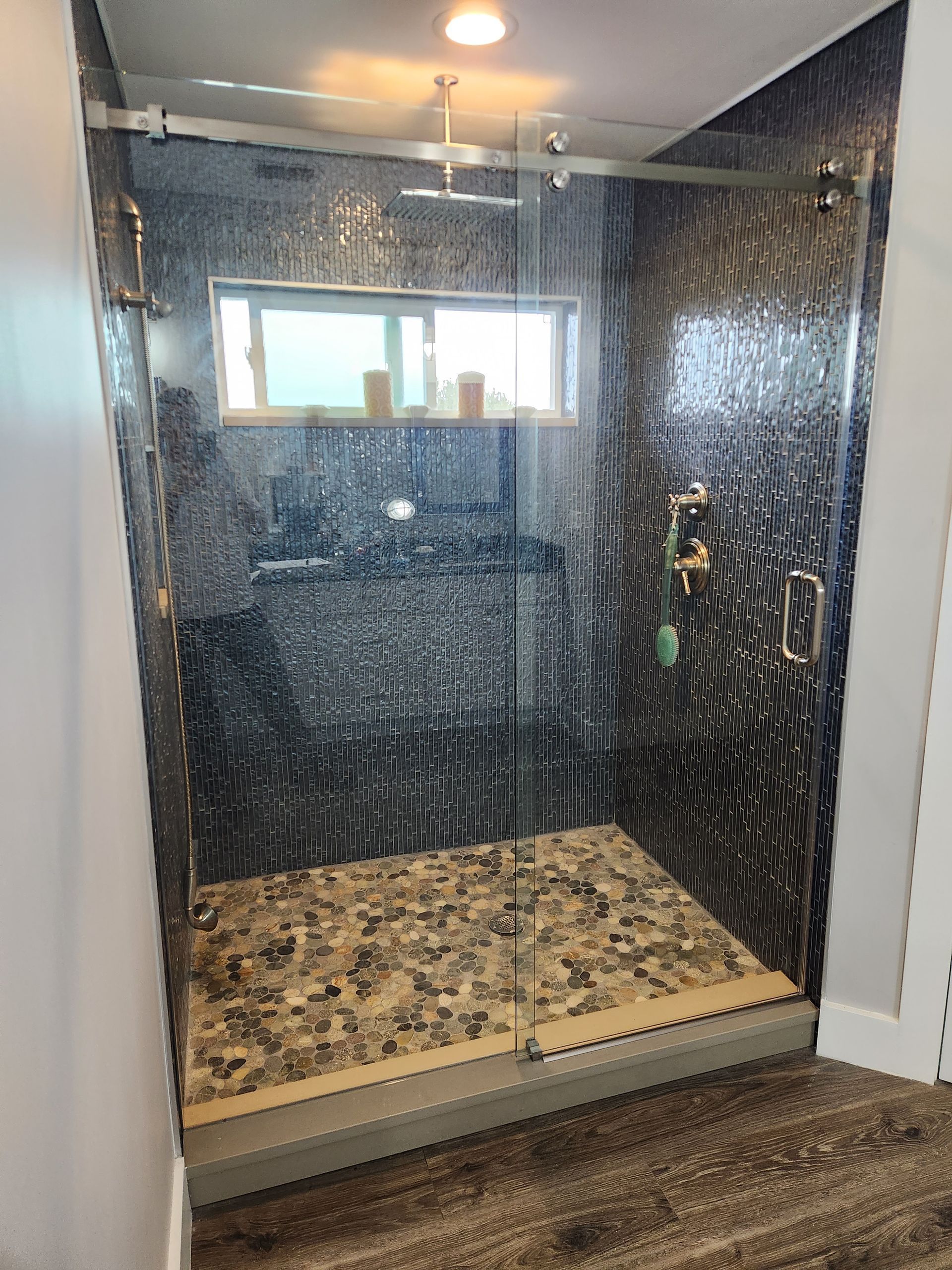 a bathroom with a walk-in shower with a sliding glass door