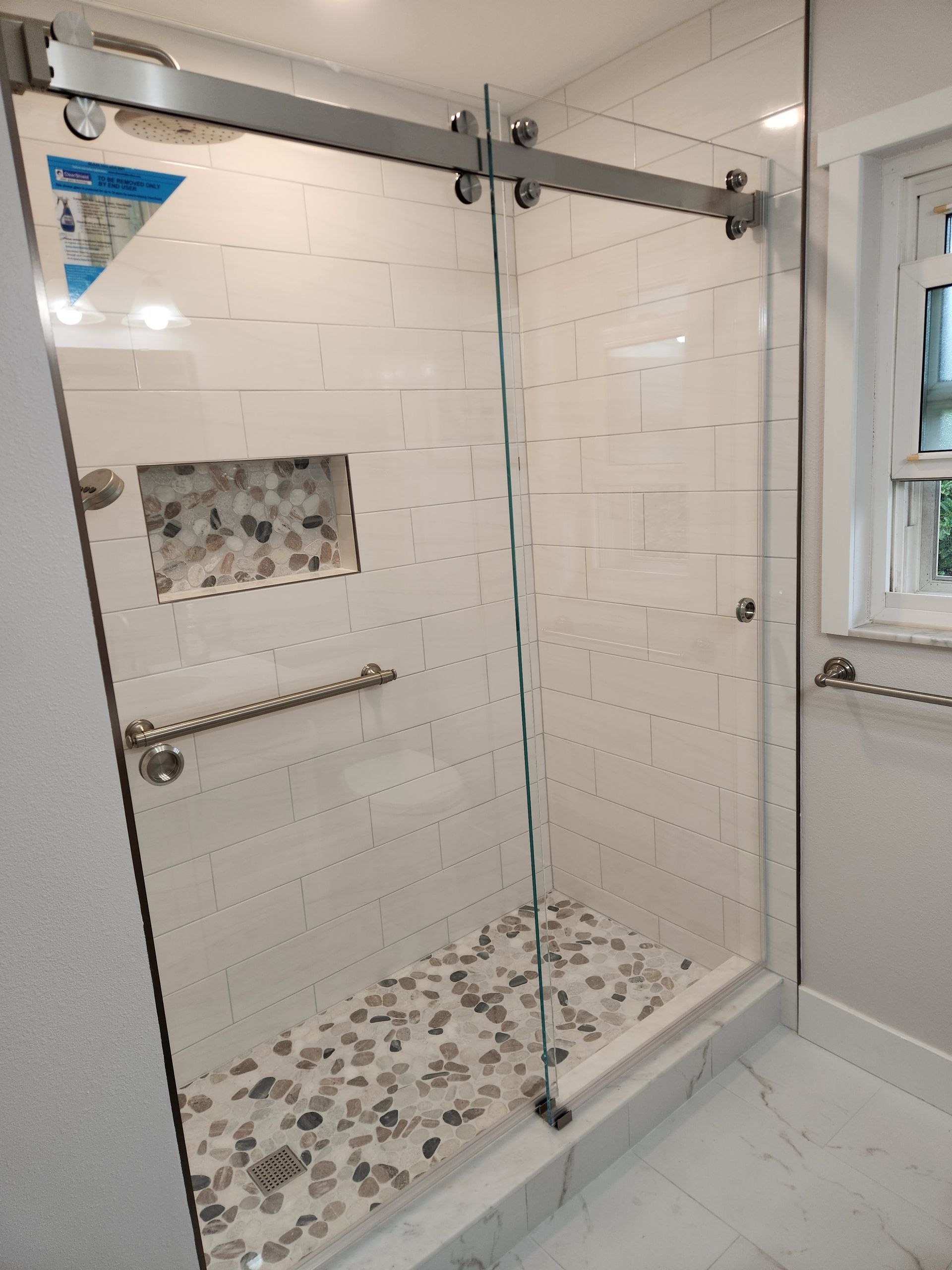 a bathroom with a sliding glass shower door