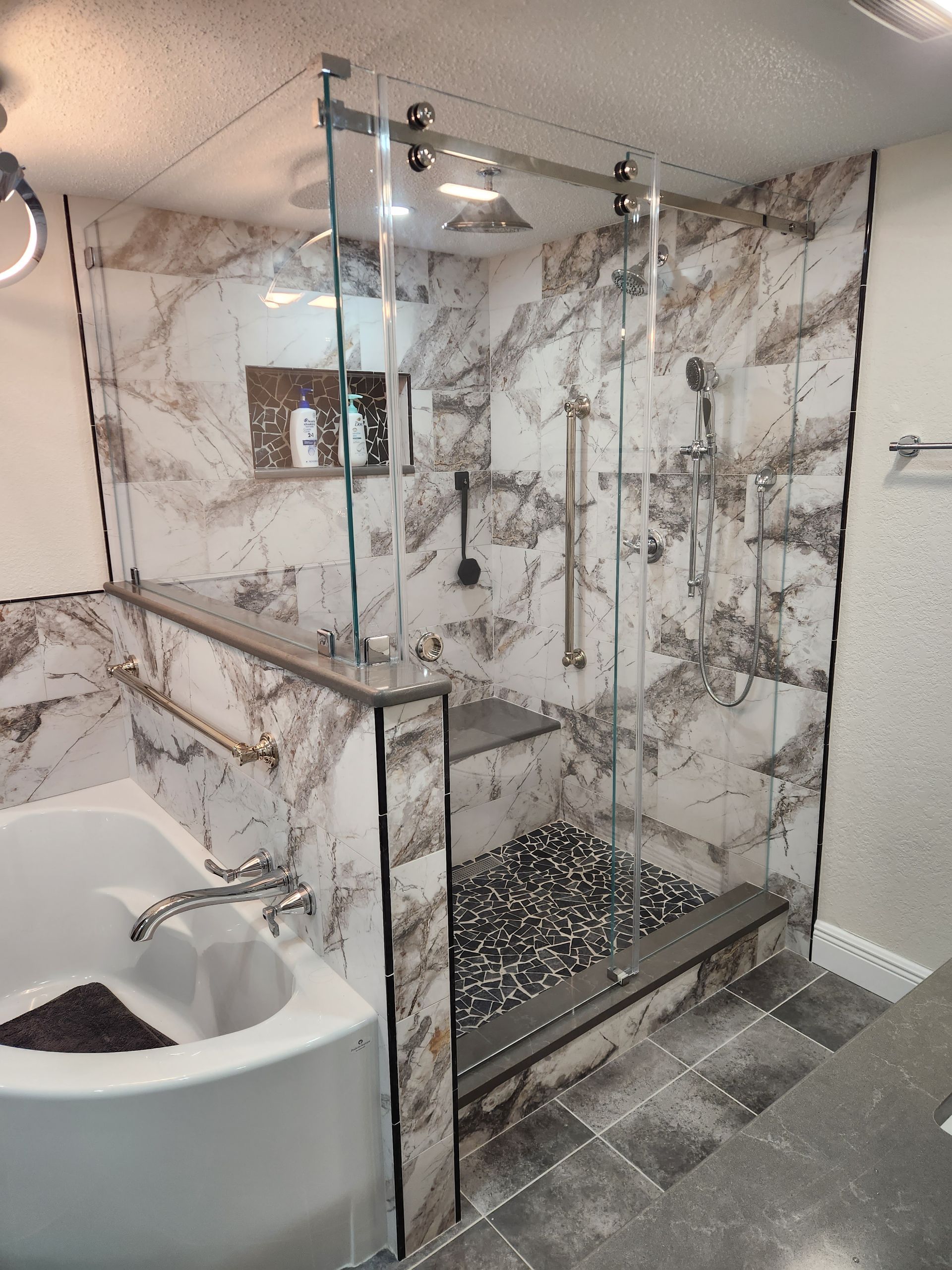 a bathroom with a tub and a shower with a glass door