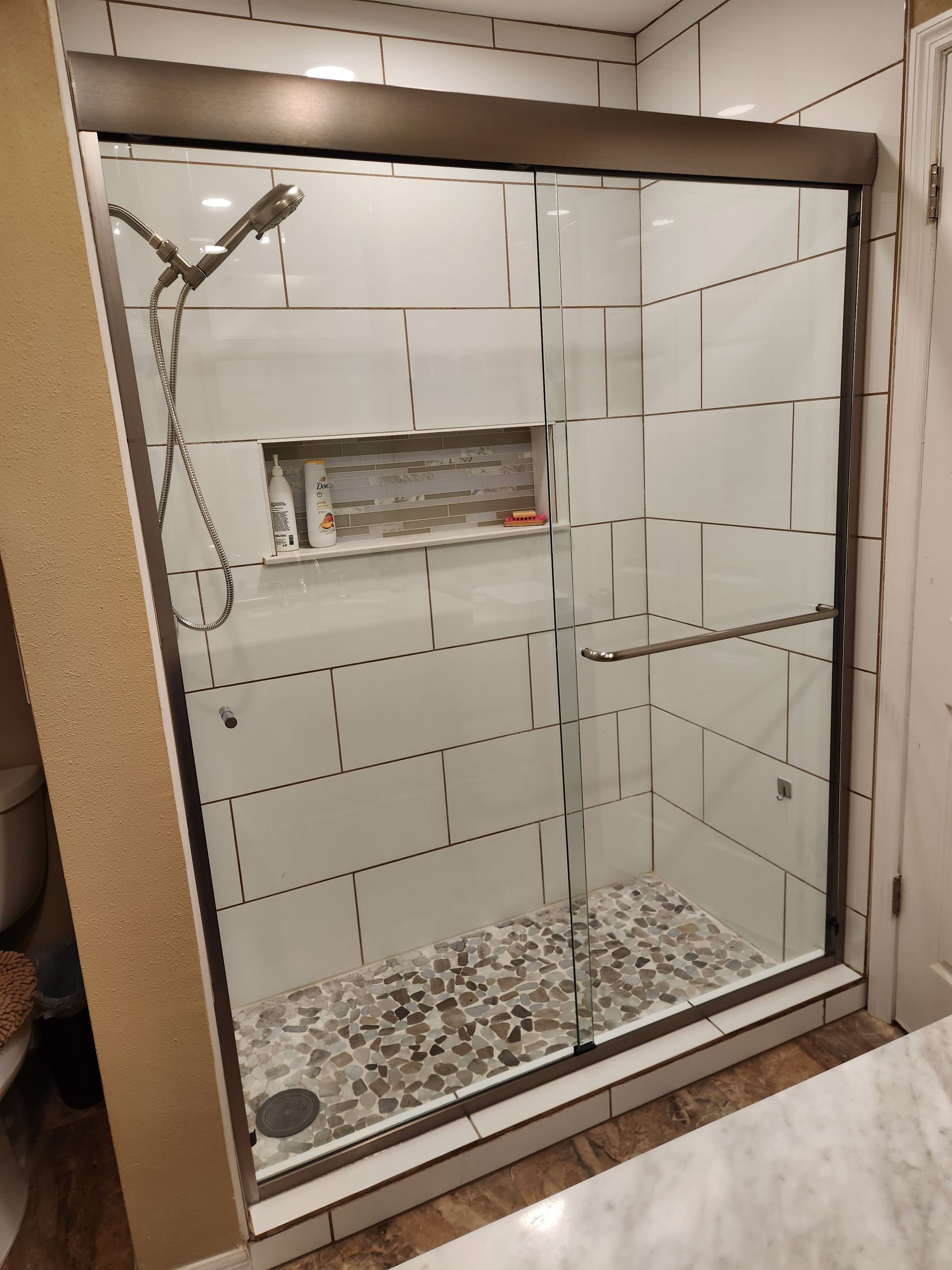 a bathroom with a sliding glass shower door and a shower head