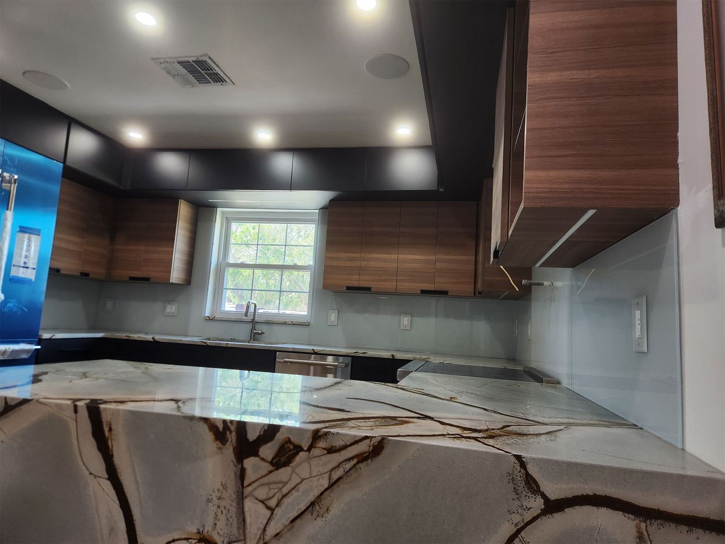 Kitchen with granite countertops, wood cabinets, and a window.