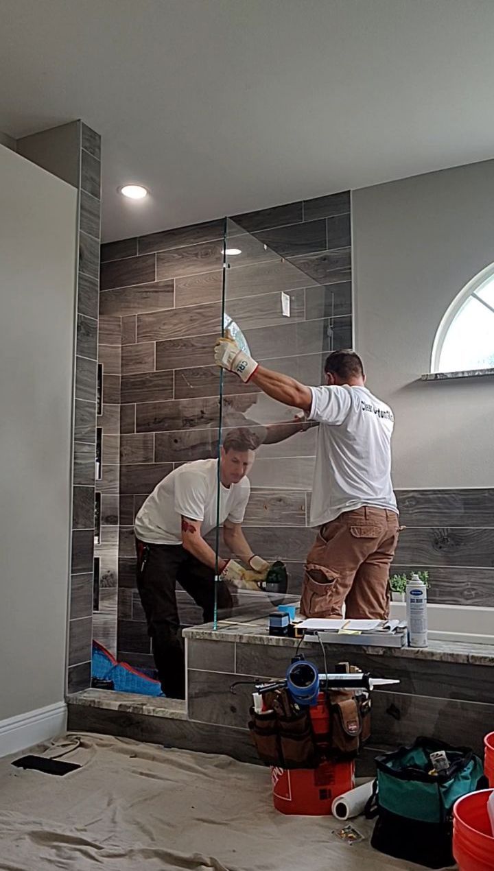Two men installing a shower door