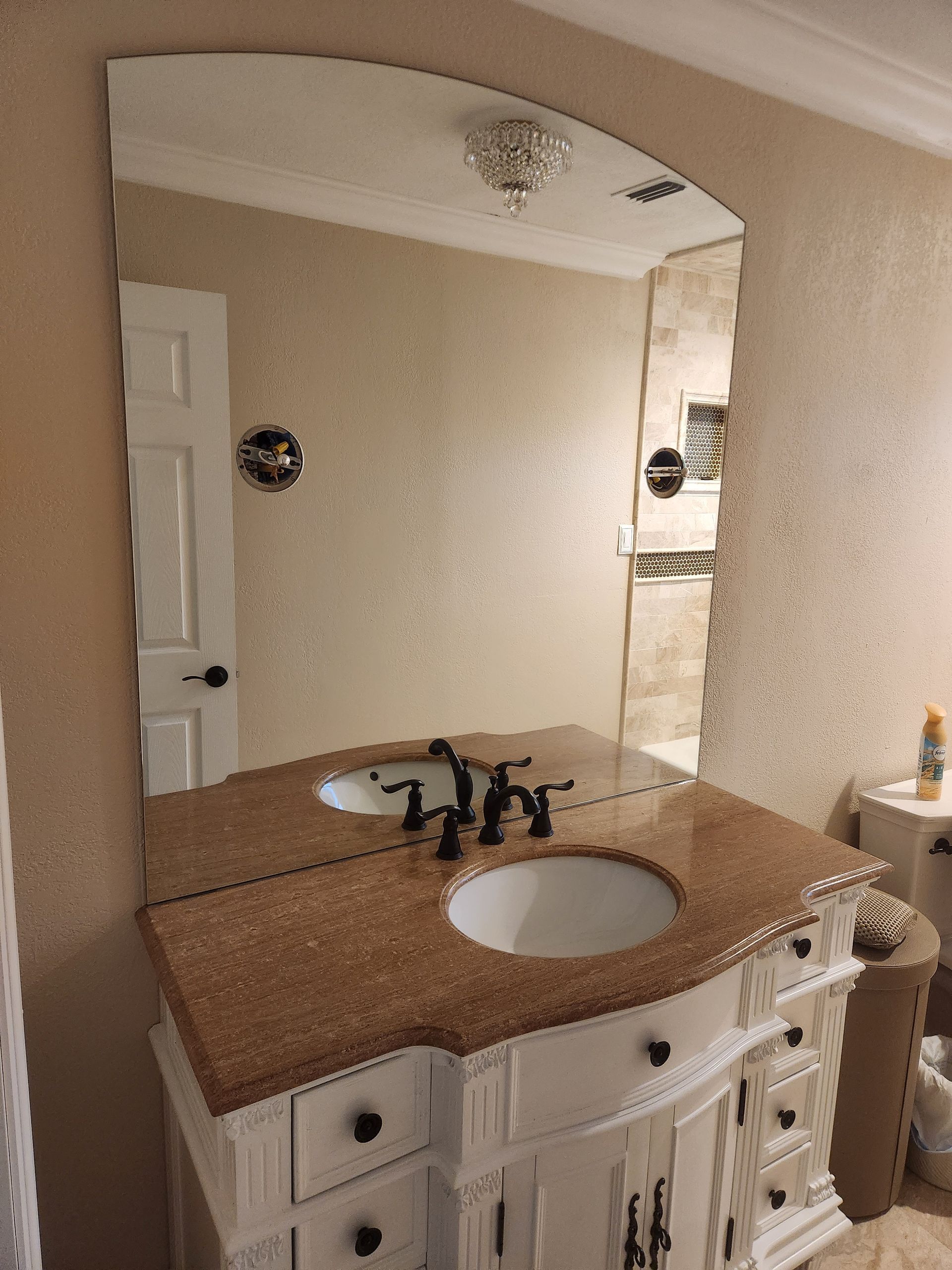 A bathroom with a sink, mirror, and vanity.