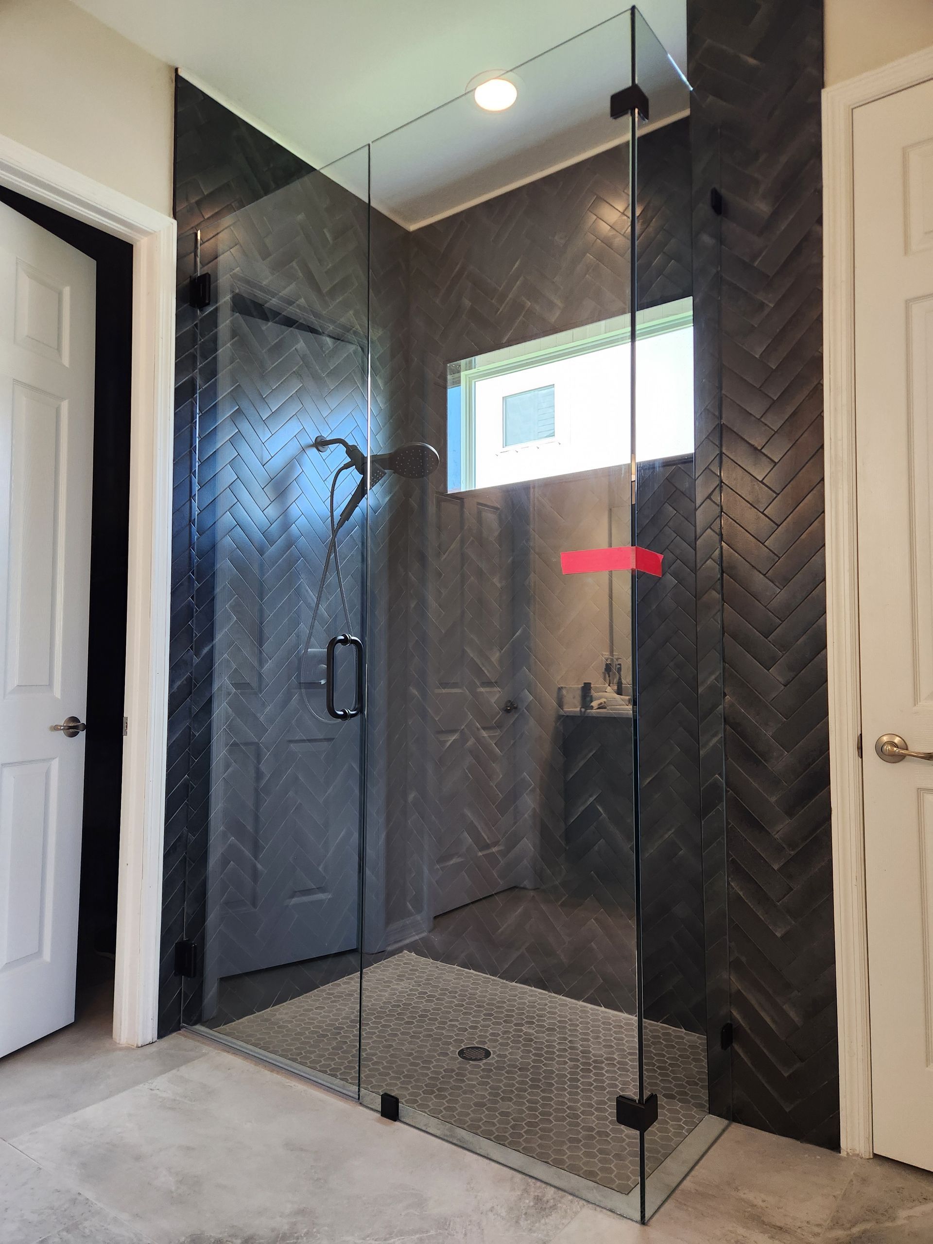 A bathroom with a walk in shower and a window