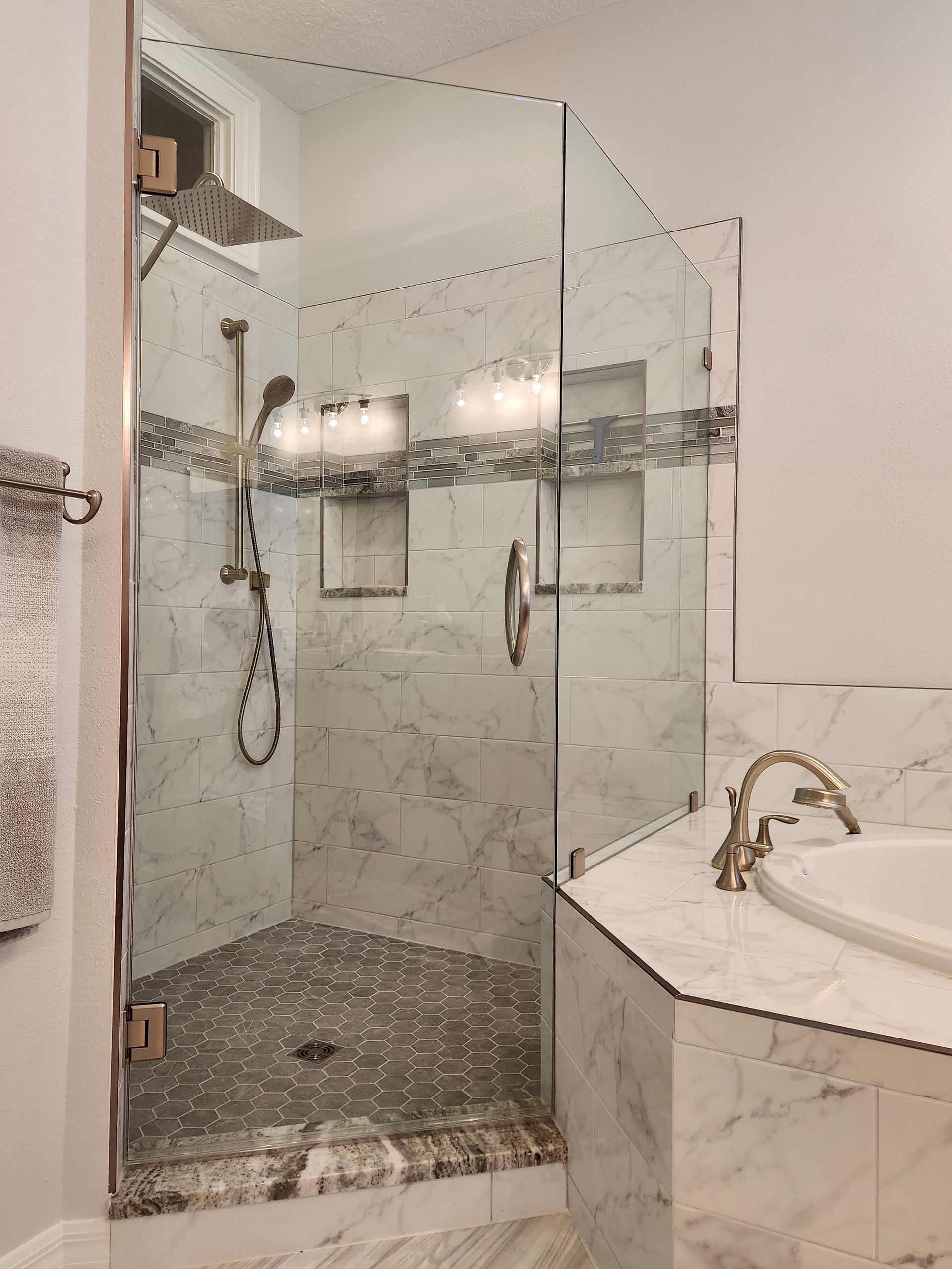 a bathroom with a walk-in shower and a tub