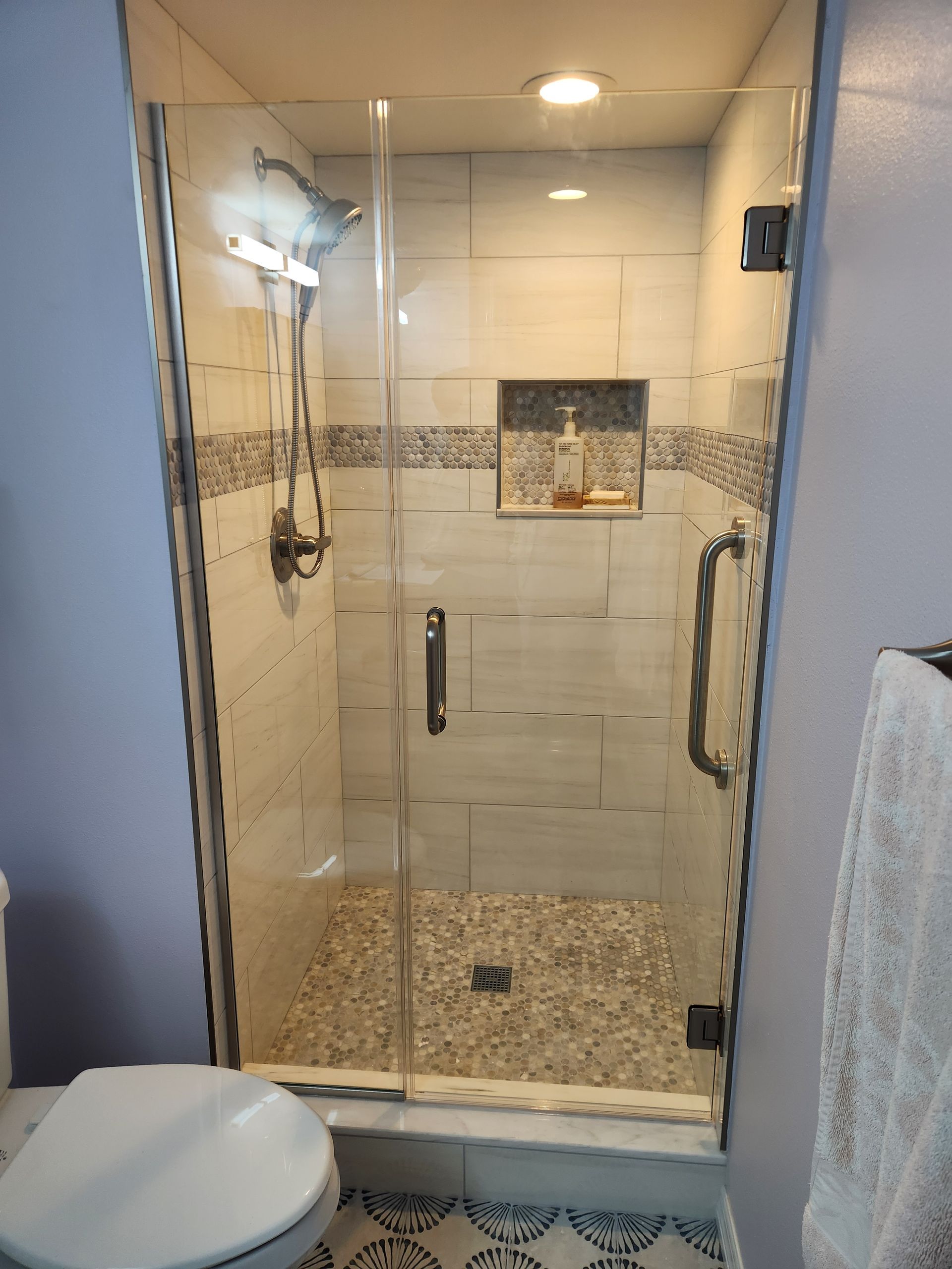 a bathroom with a toilet and a shower with a glass door