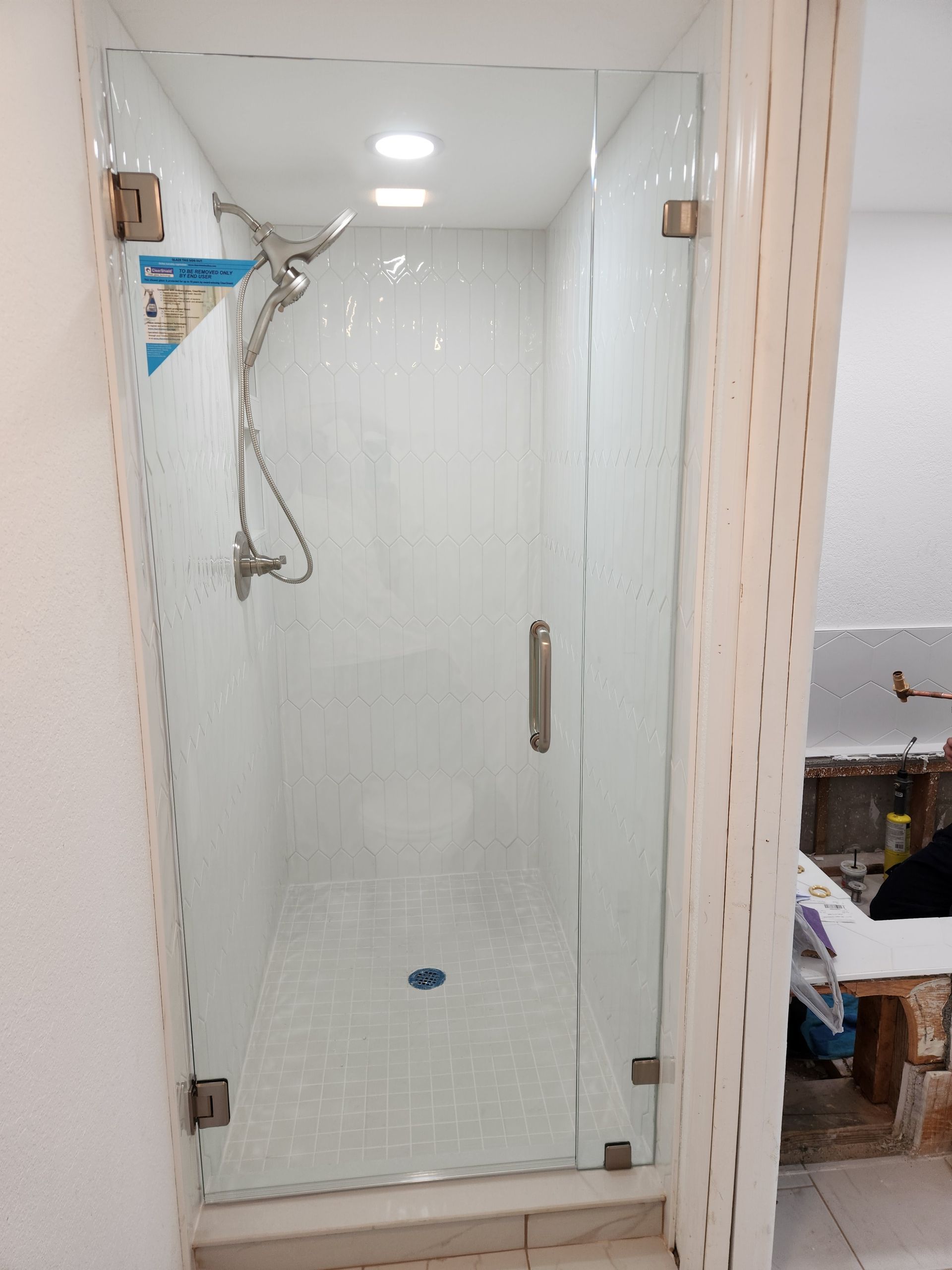 a bathroom with a glass shower door and a shower head
