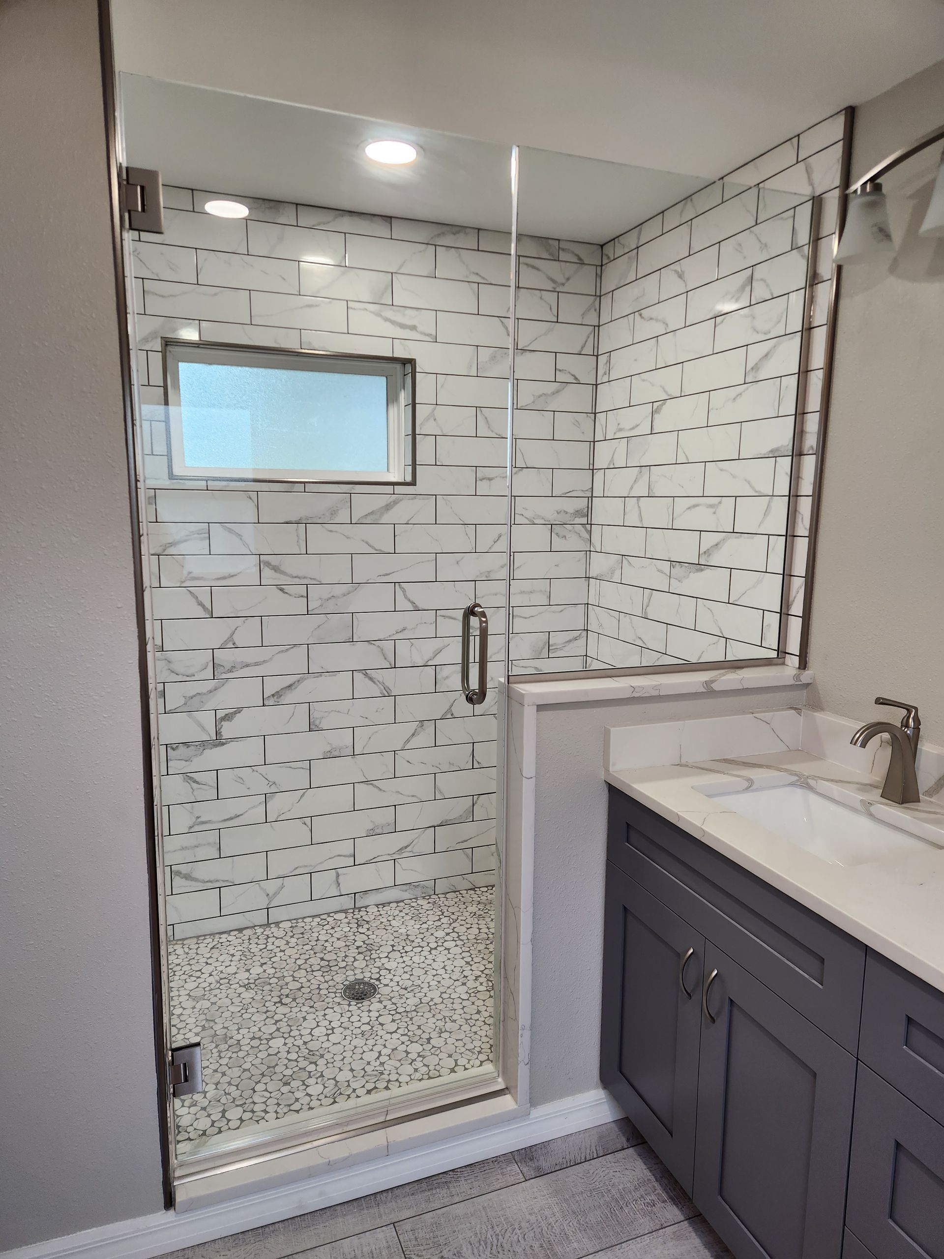 a bathroom with a walk-in shower and a sink
