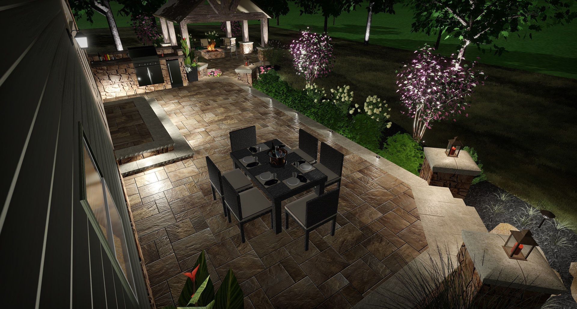 Nighttime patio with a dining table, gazebo, and lit trees beside a lawn.