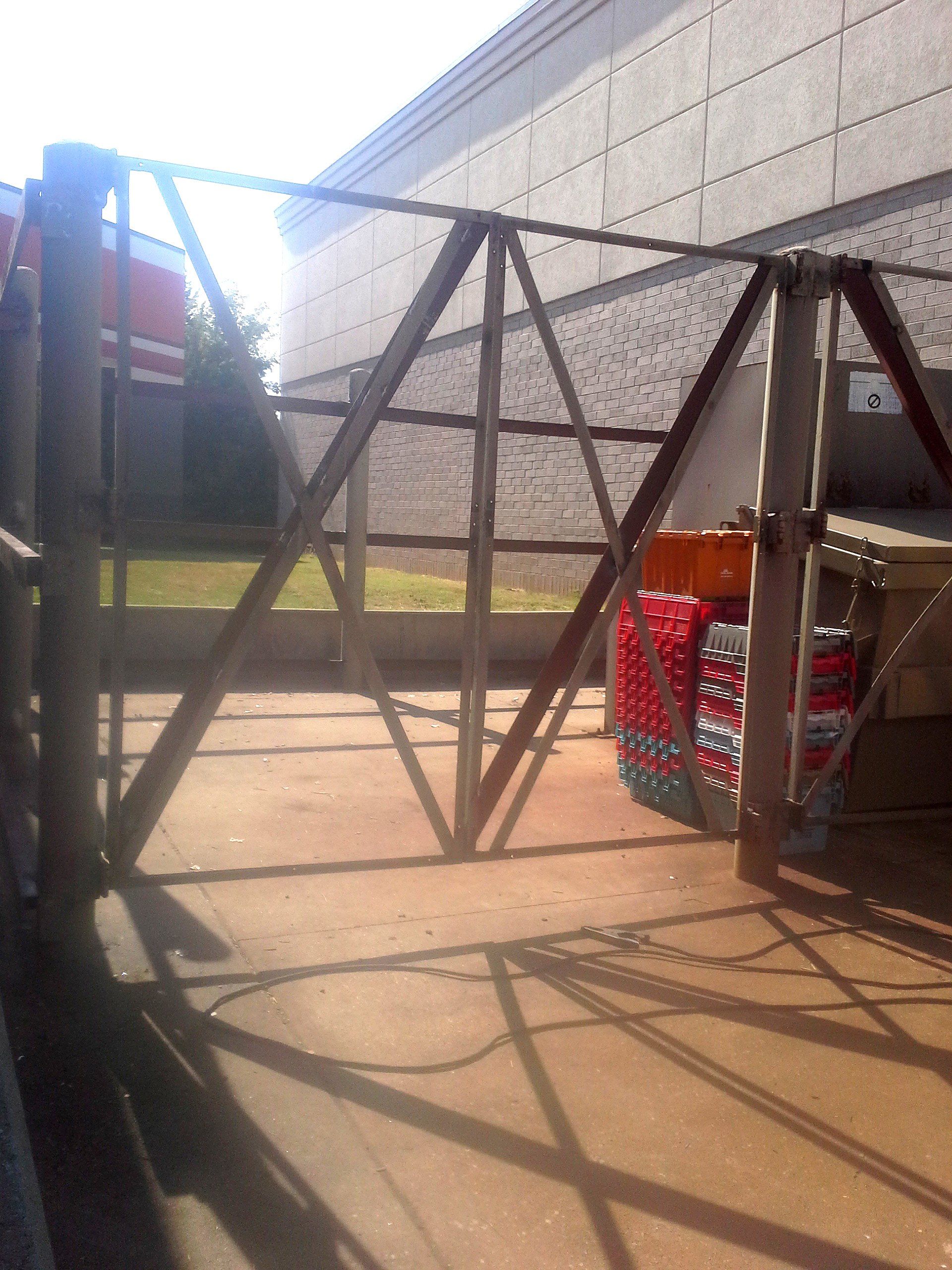 A fence with a brick wall in the background