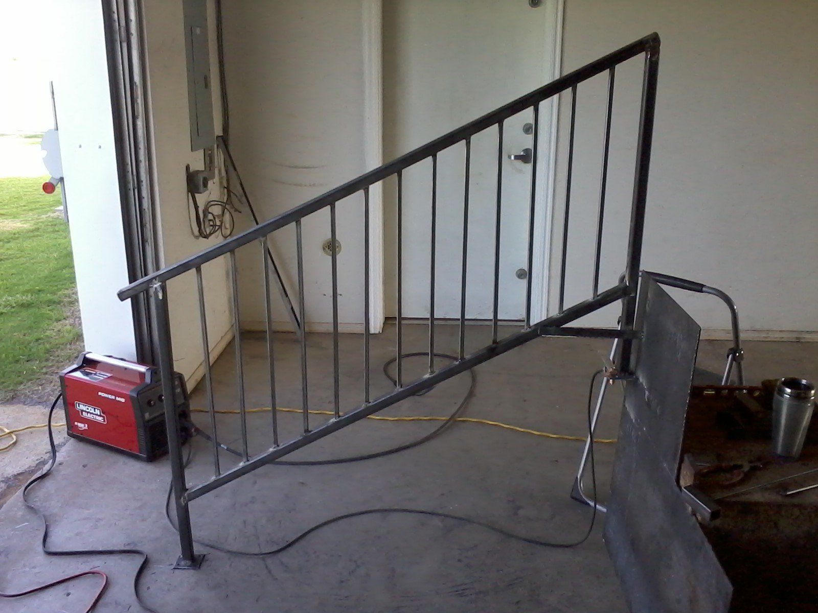 A welding machine is sitting next to a metal railing