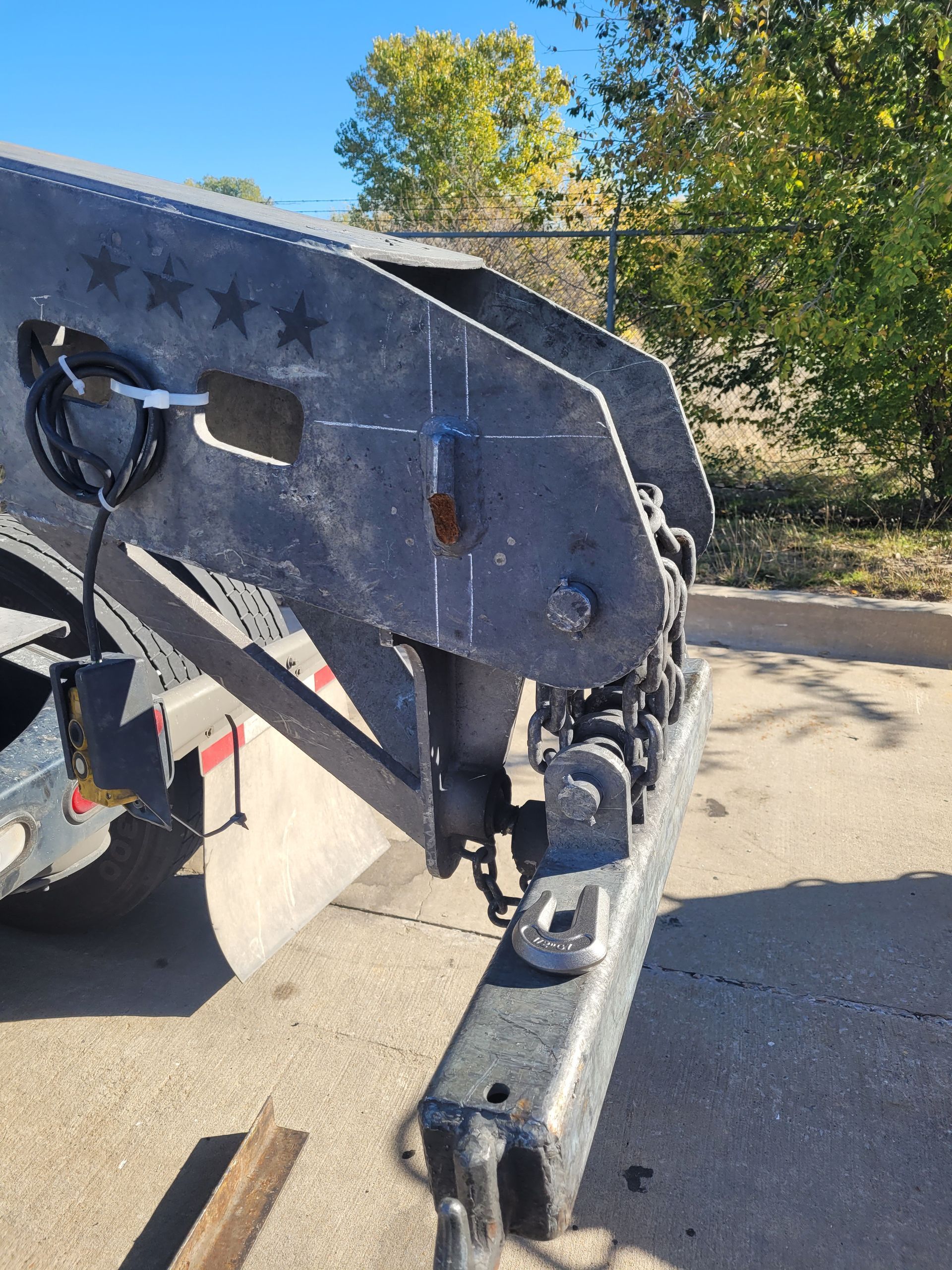 A truck with a trailer attached to it is parked on the side of the road.