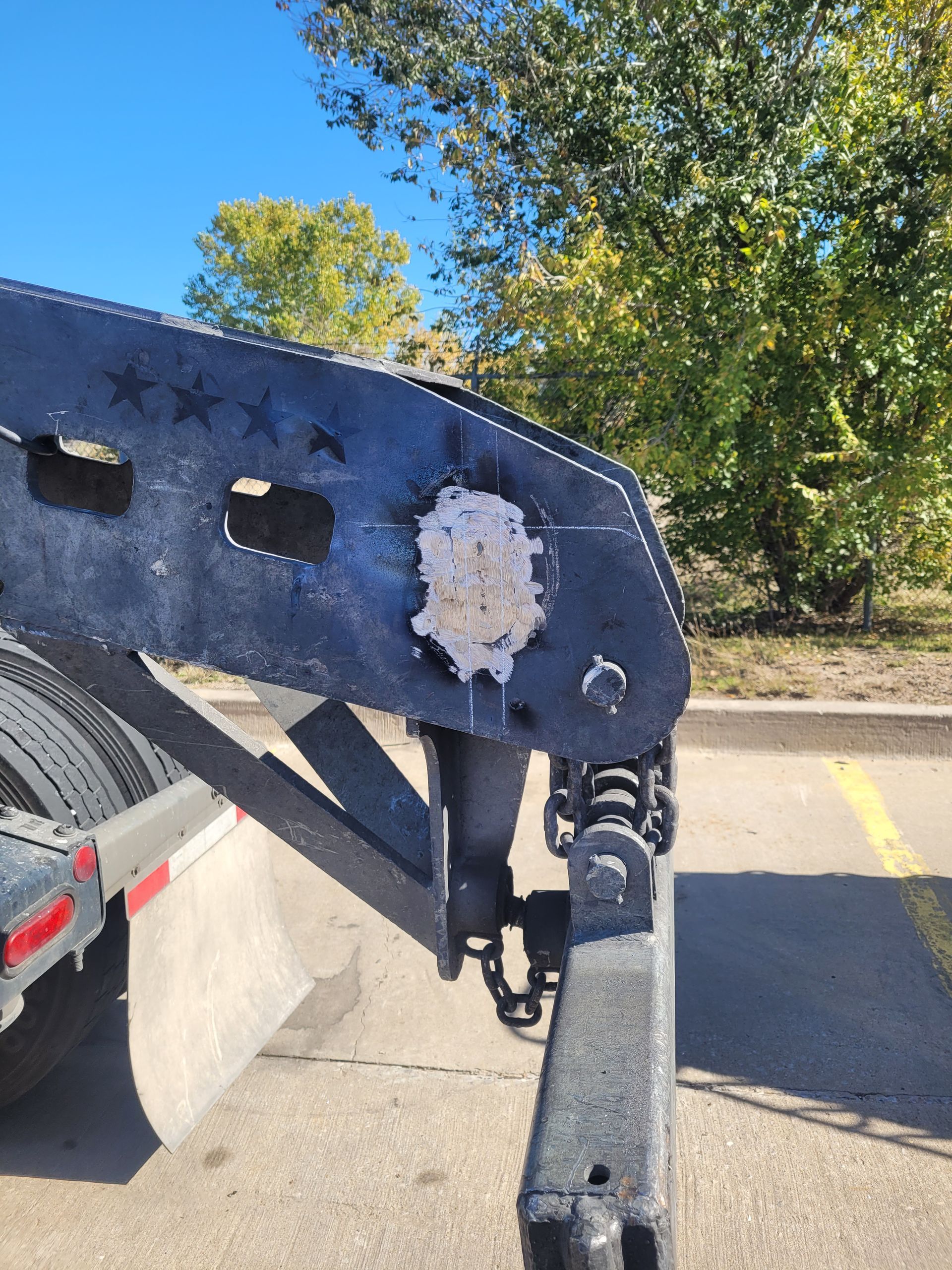 A trailer is parked on the side of the road in a parking lot.
