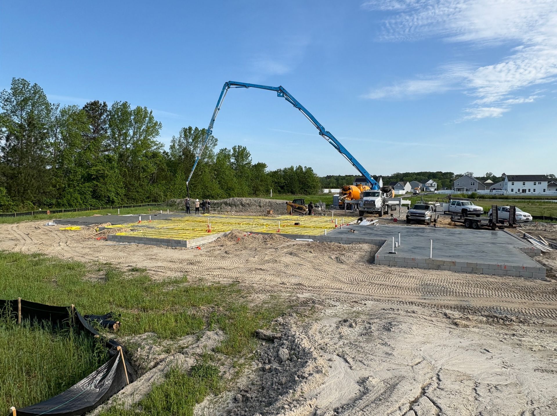 A concrete pump is being used to pour concrete on a construction site.