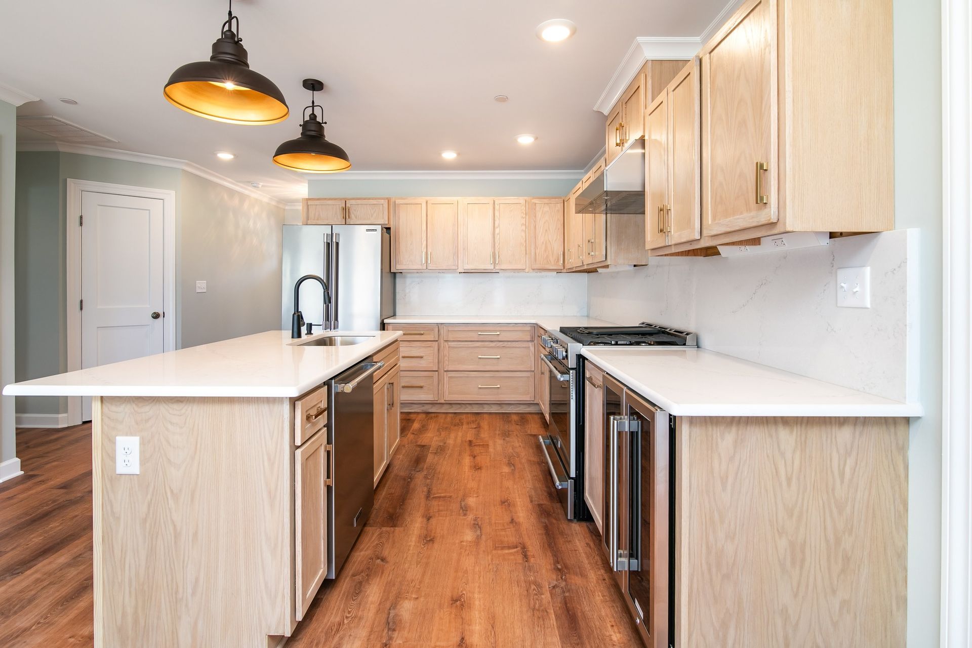 A kitchen with wooden cabinets , stainless steel appliances , and a large island.