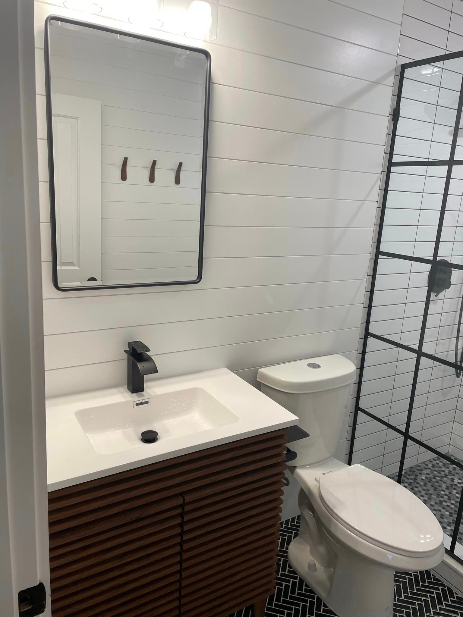 A bathroom with a sink , toilet and mirror.