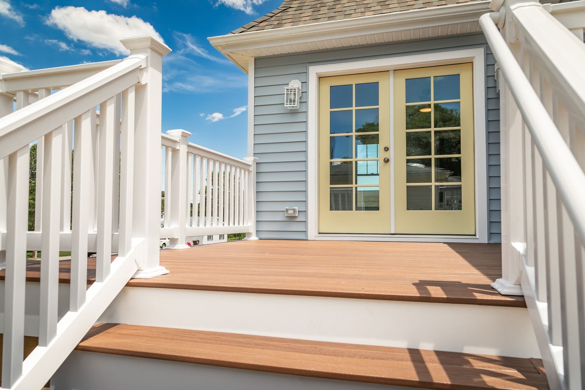 A house with a wooden deck and stairs leading to the front door.