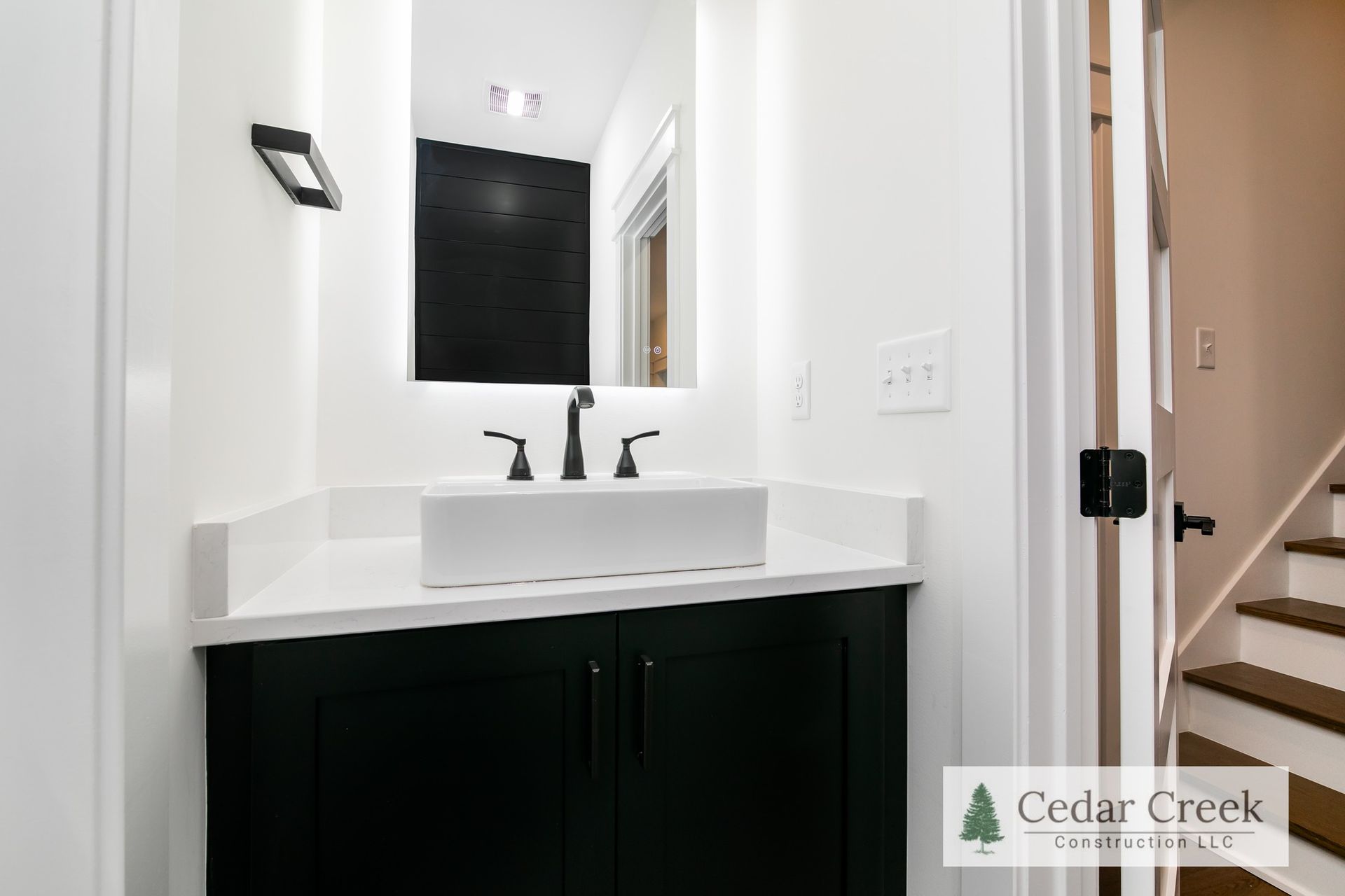A bathroom with a sink, mirror and stairs