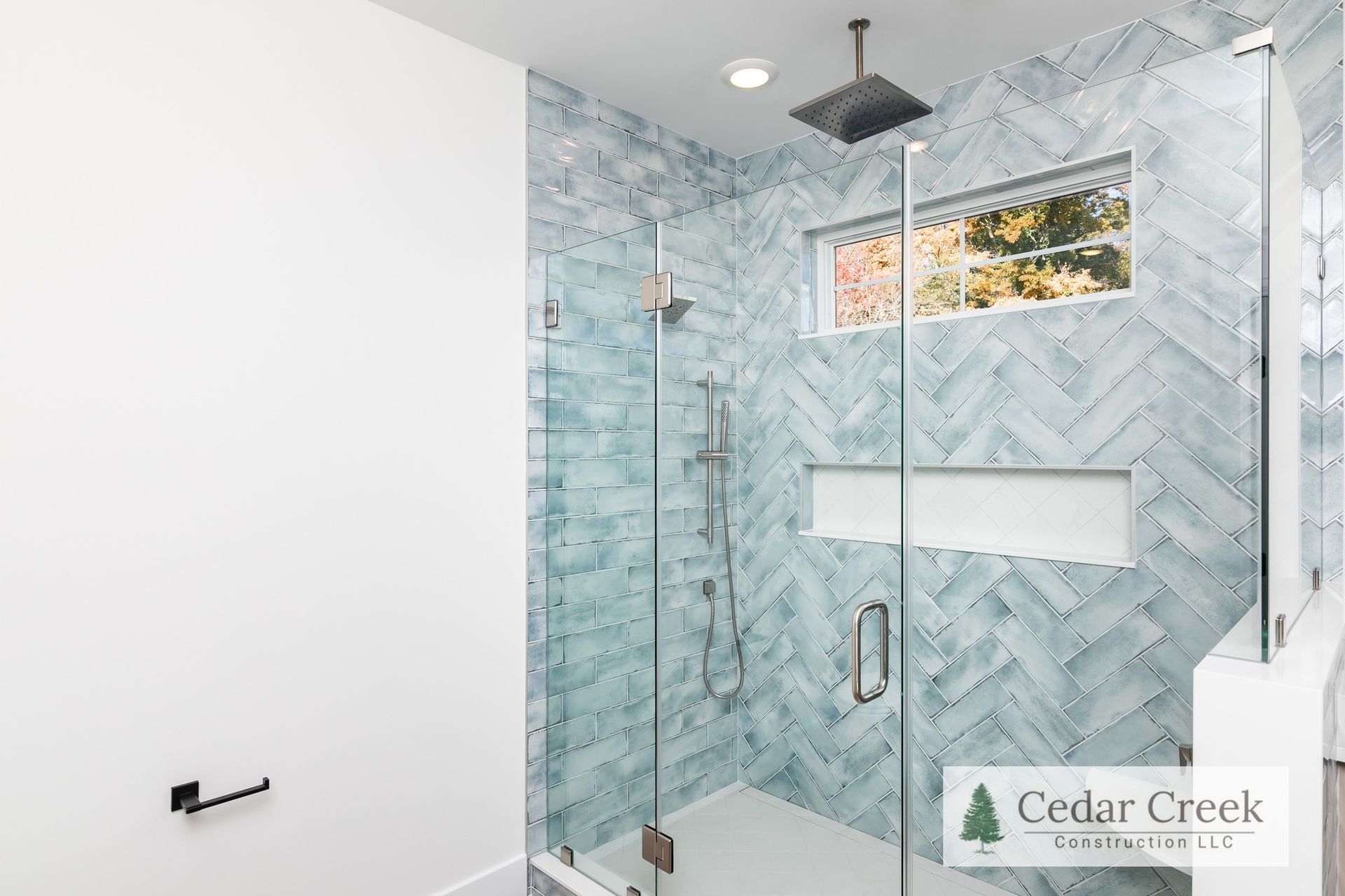 A bathroom with a walk in shower and a window