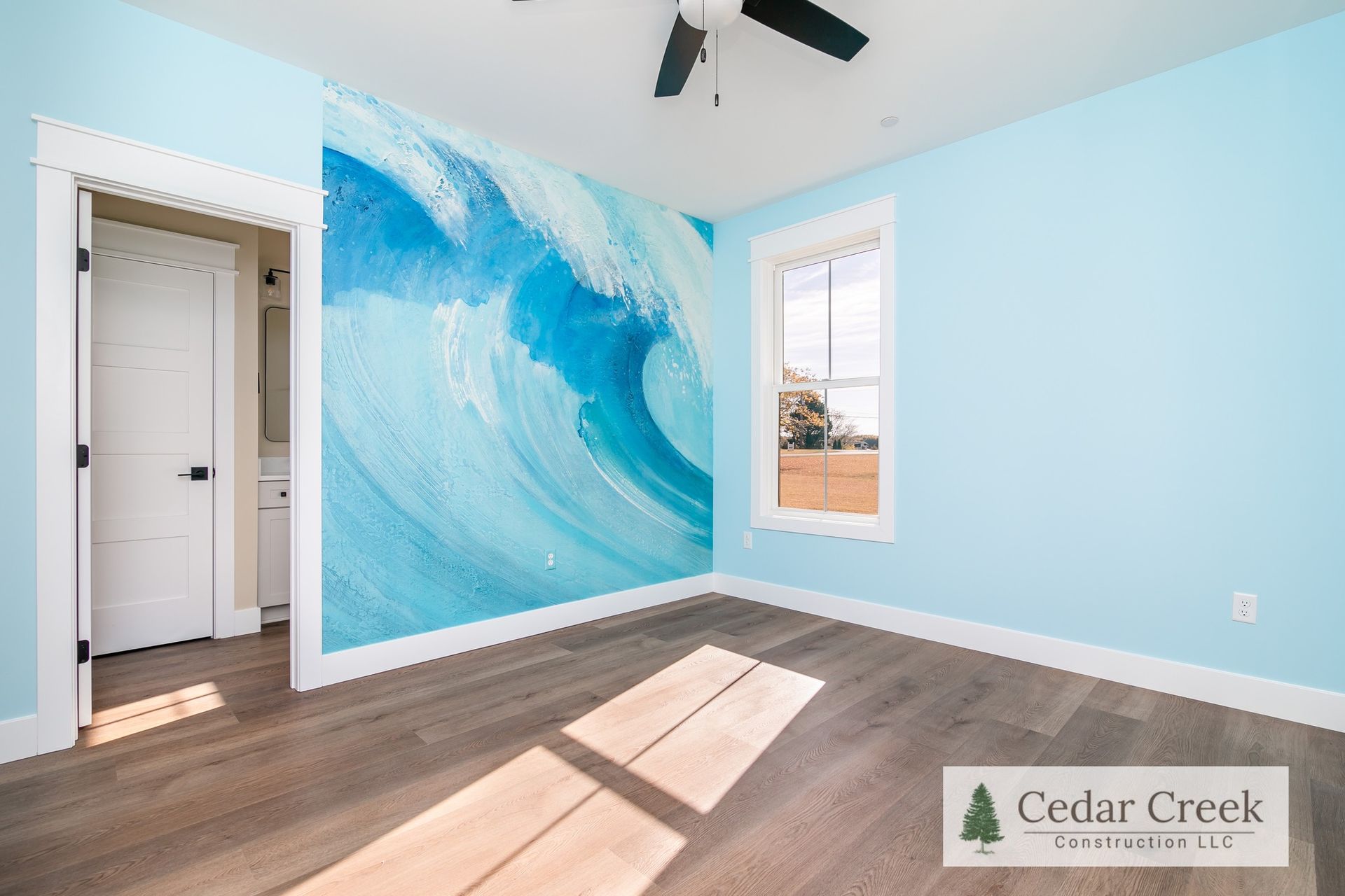 A bedroom with a painting of a wave on the wall