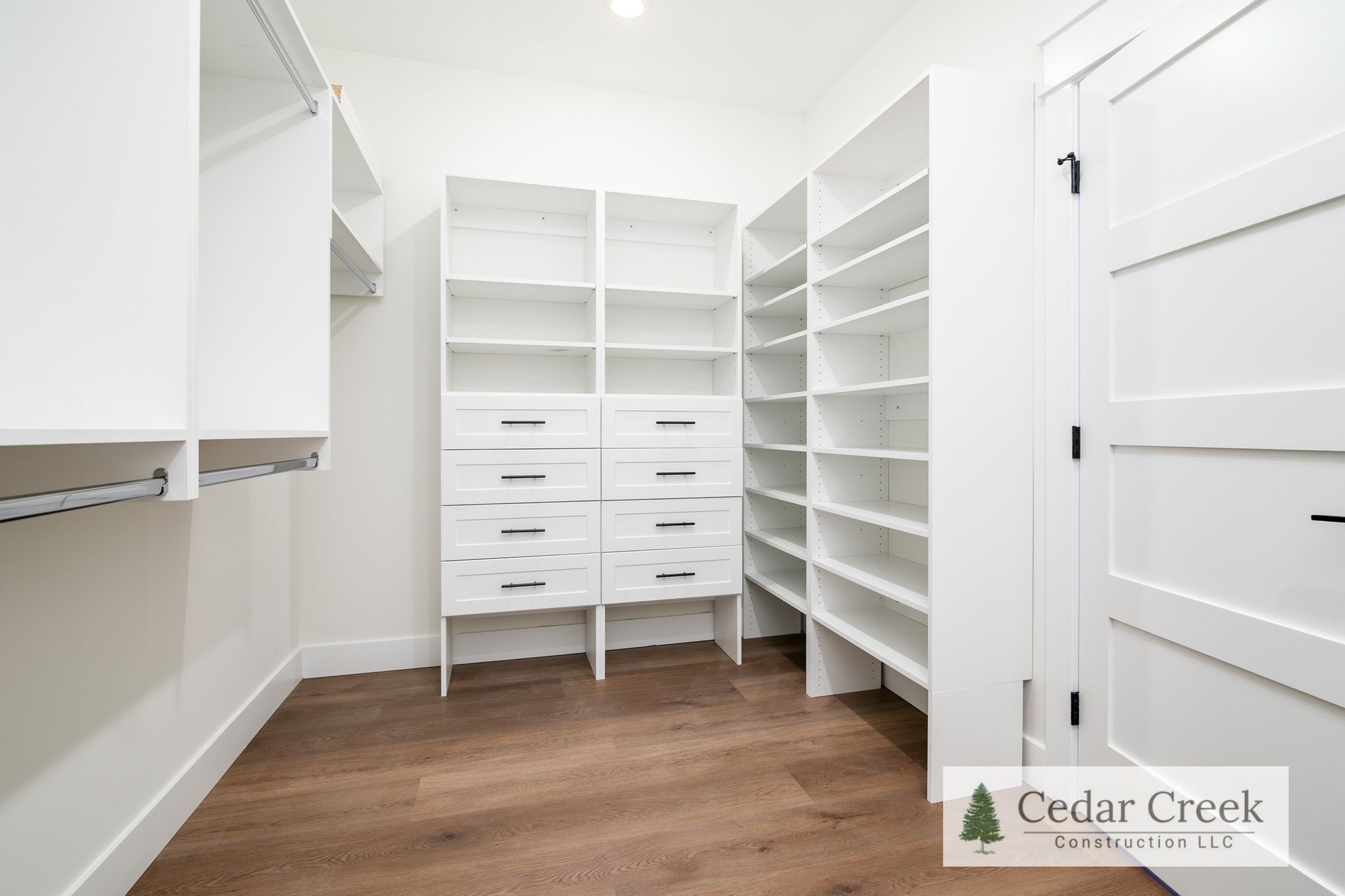 A walk in closet with lots of shelves and drawers
