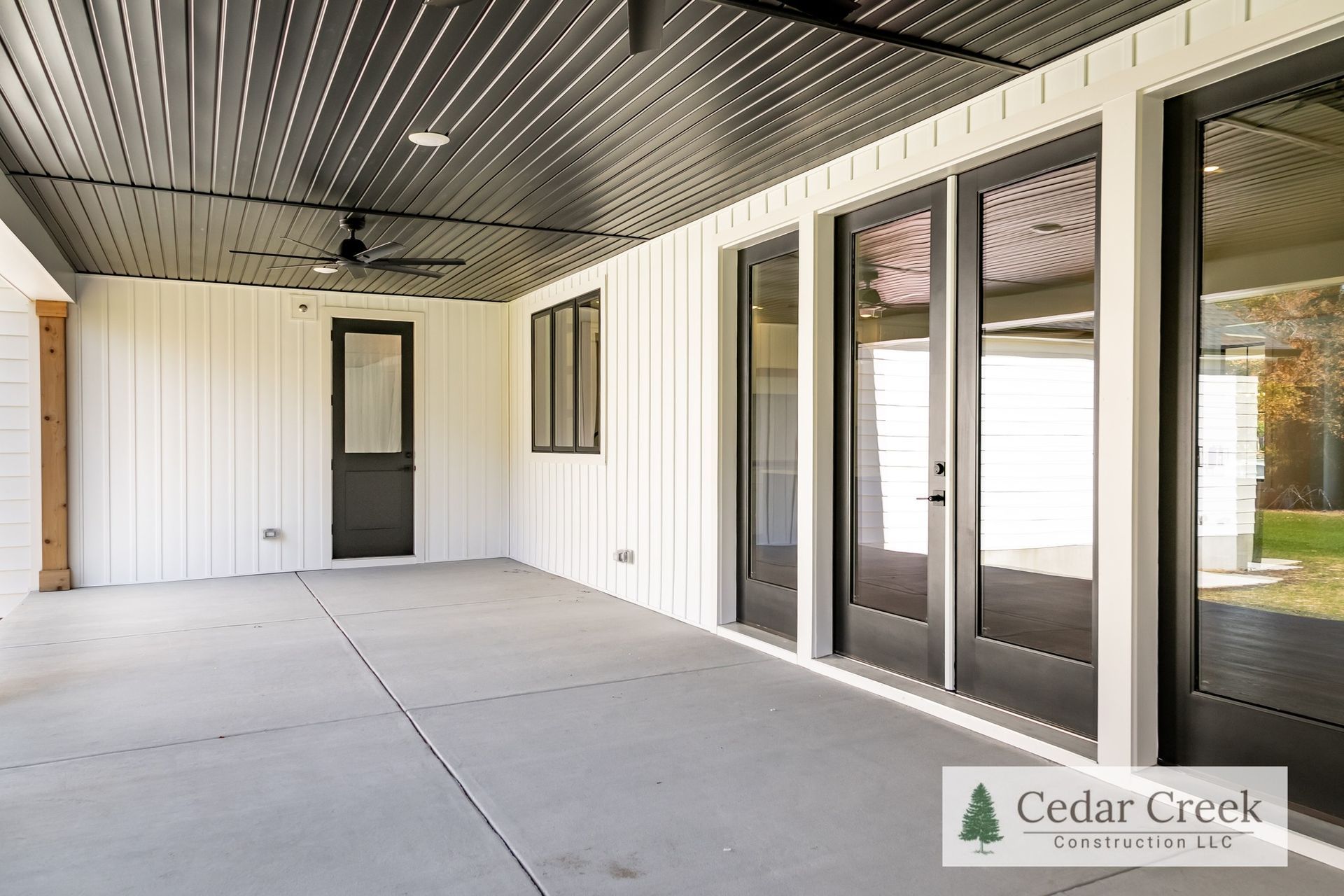 A large patio with sliding glass doors and a ceiling fan