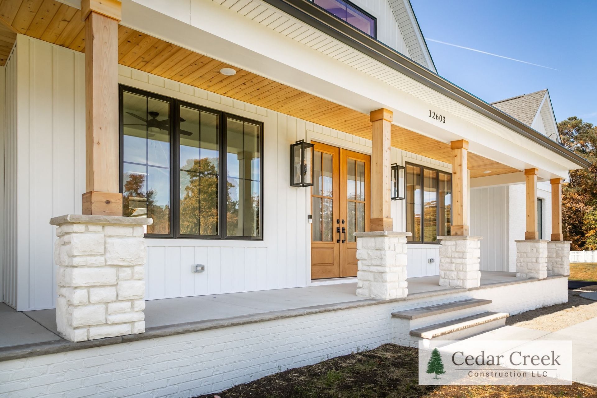 A white house with a large porch and a lot of windows