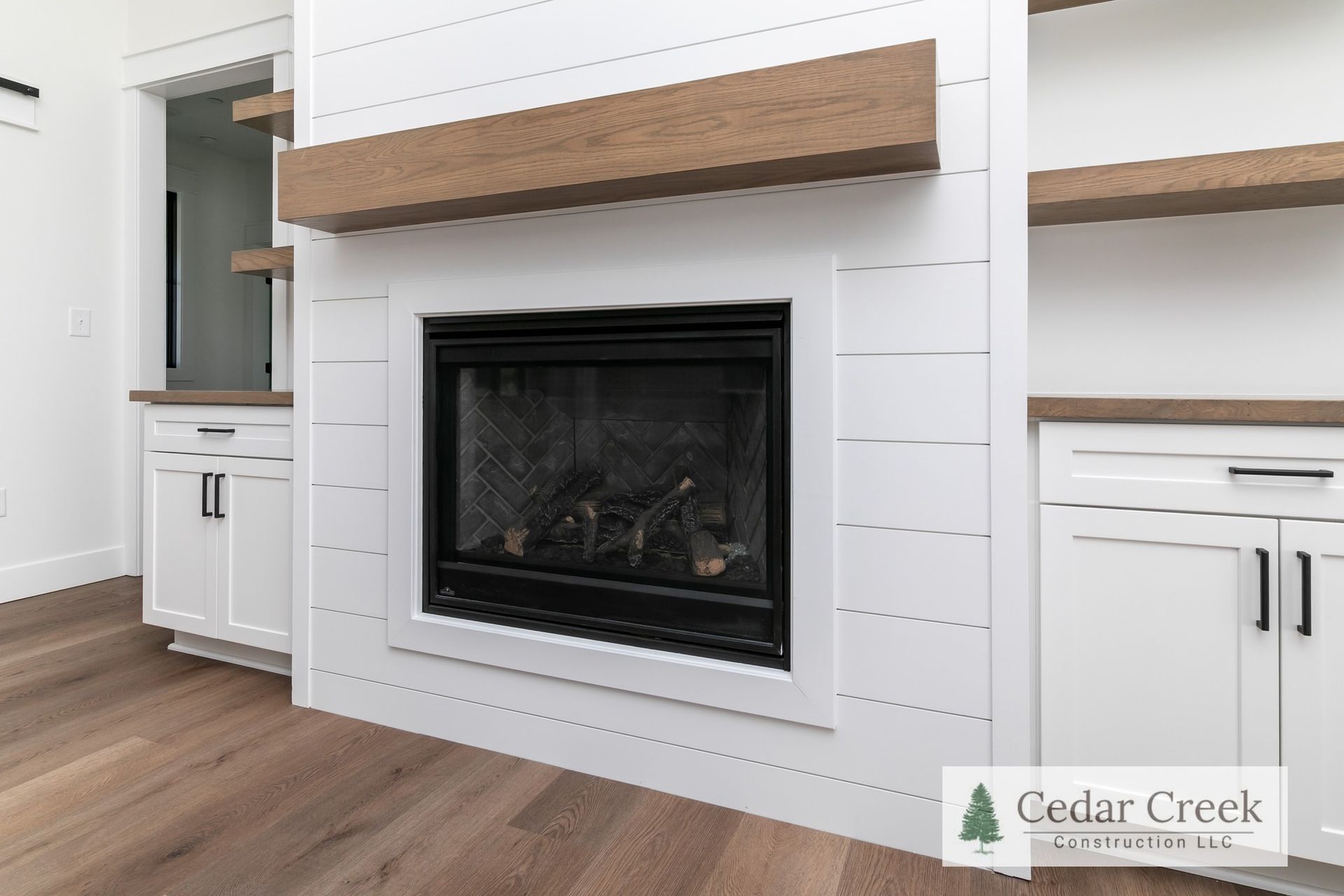 A fireplace with a wooden mantle in a living room