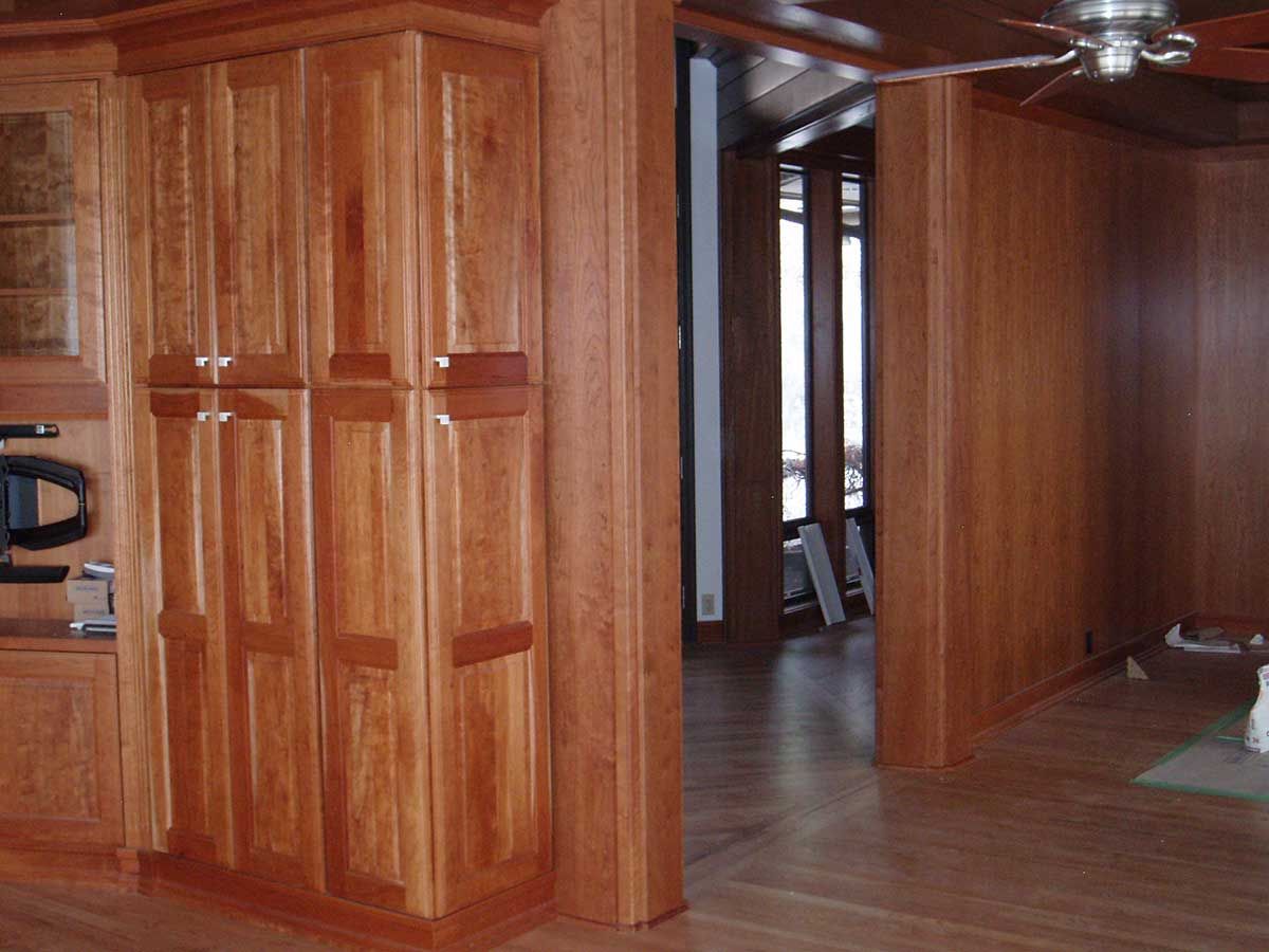 A room with wooden cabinets and a ceiling fan