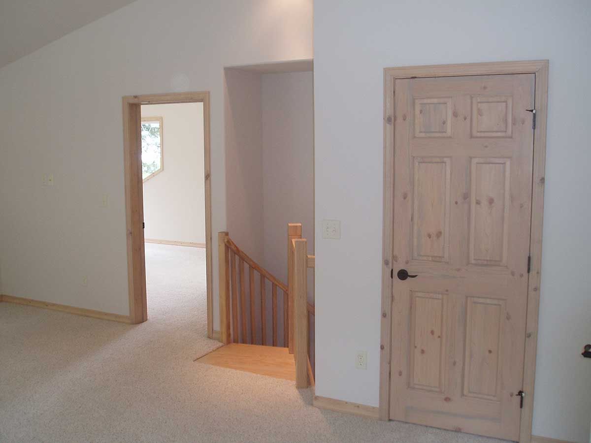 An empty room with a staircase and a door