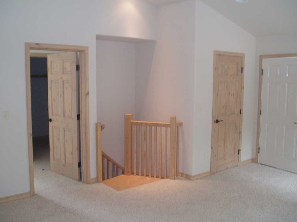 An empty room with a wooden railing and stairs