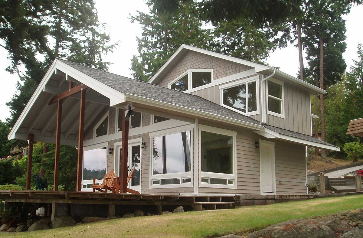 A house with a lot of windows sits on a hill