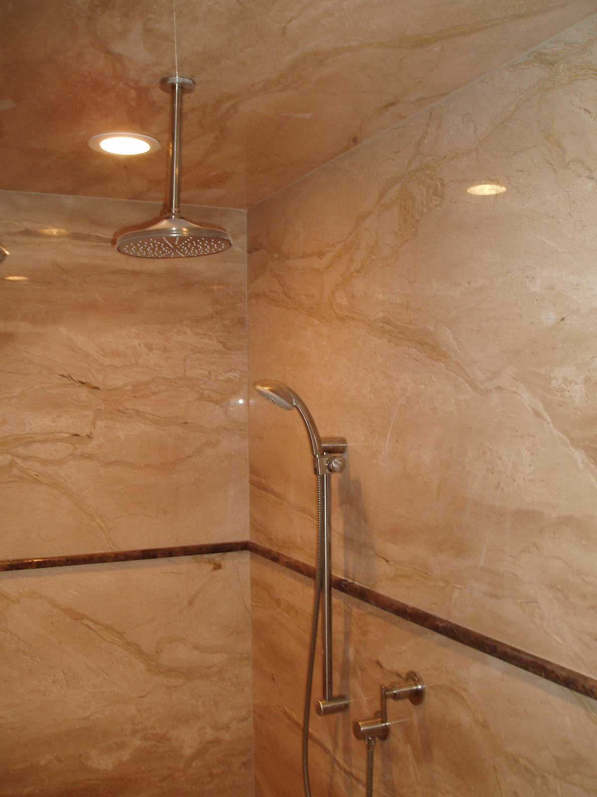 A shower head is hanging from the ceiling in a bathroom.