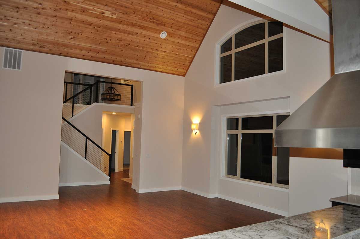 An empty house with a staircase and a stainless steel hood
