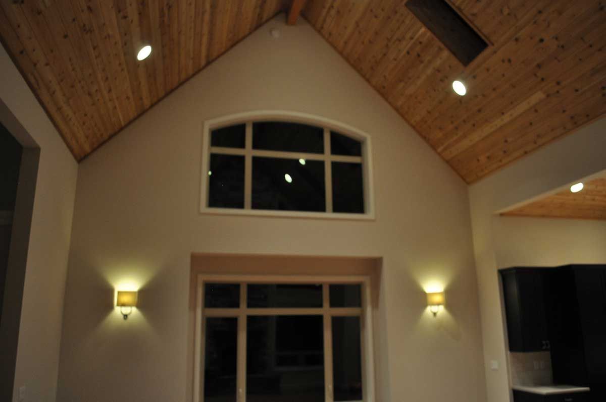 A room with a vaulted ceiling and a large window