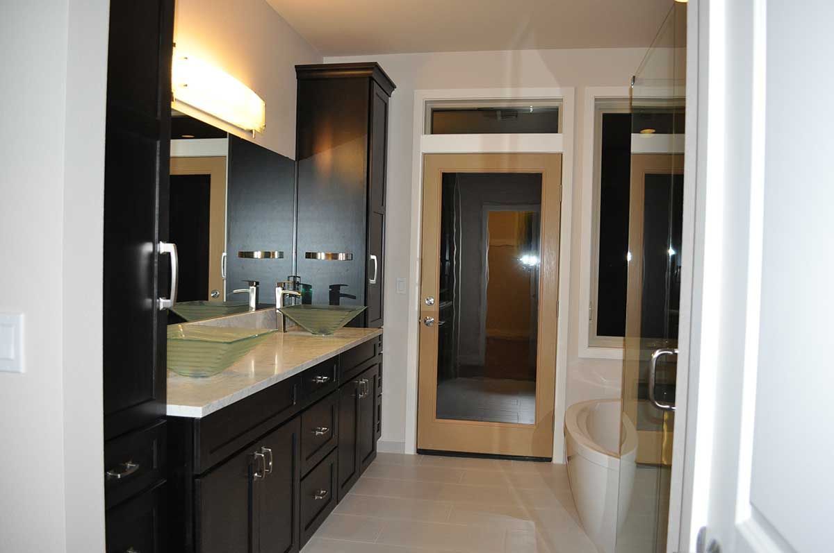 A bathroom with two sinks and a glass door