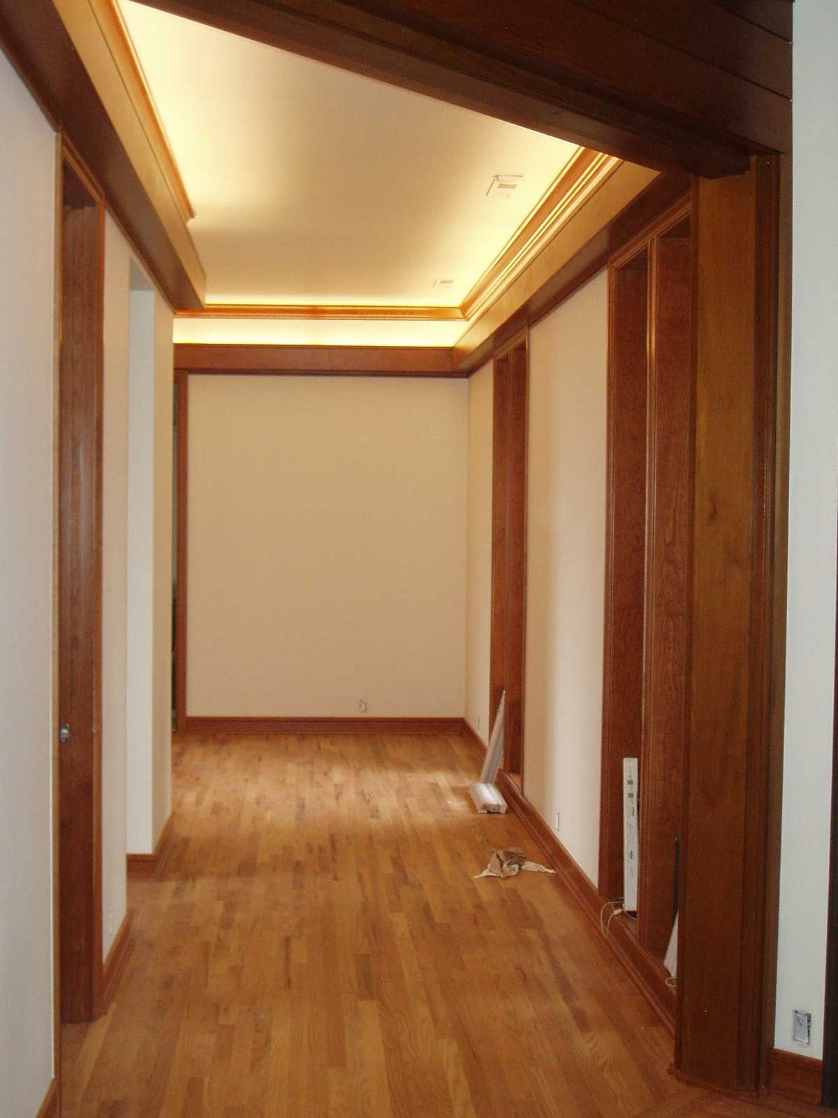 An empty hallway with wooden floors and white walls