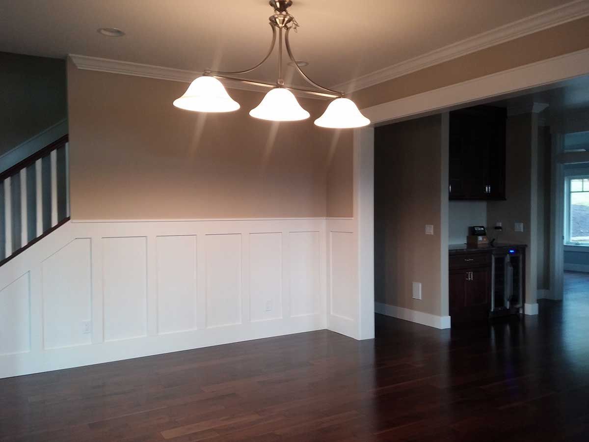 An empty dining room with a chandelier hanging from the ceiling