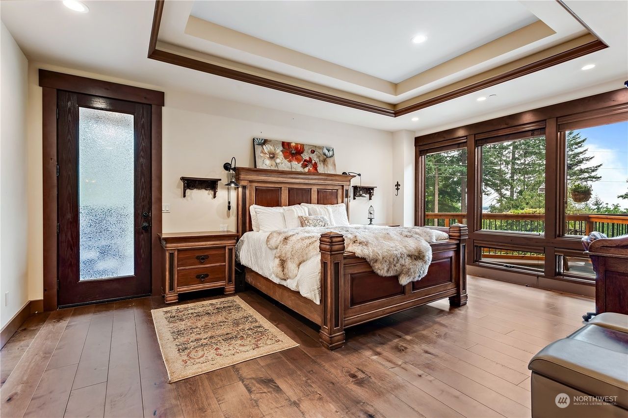A bedroom with a large bed and lots of windows