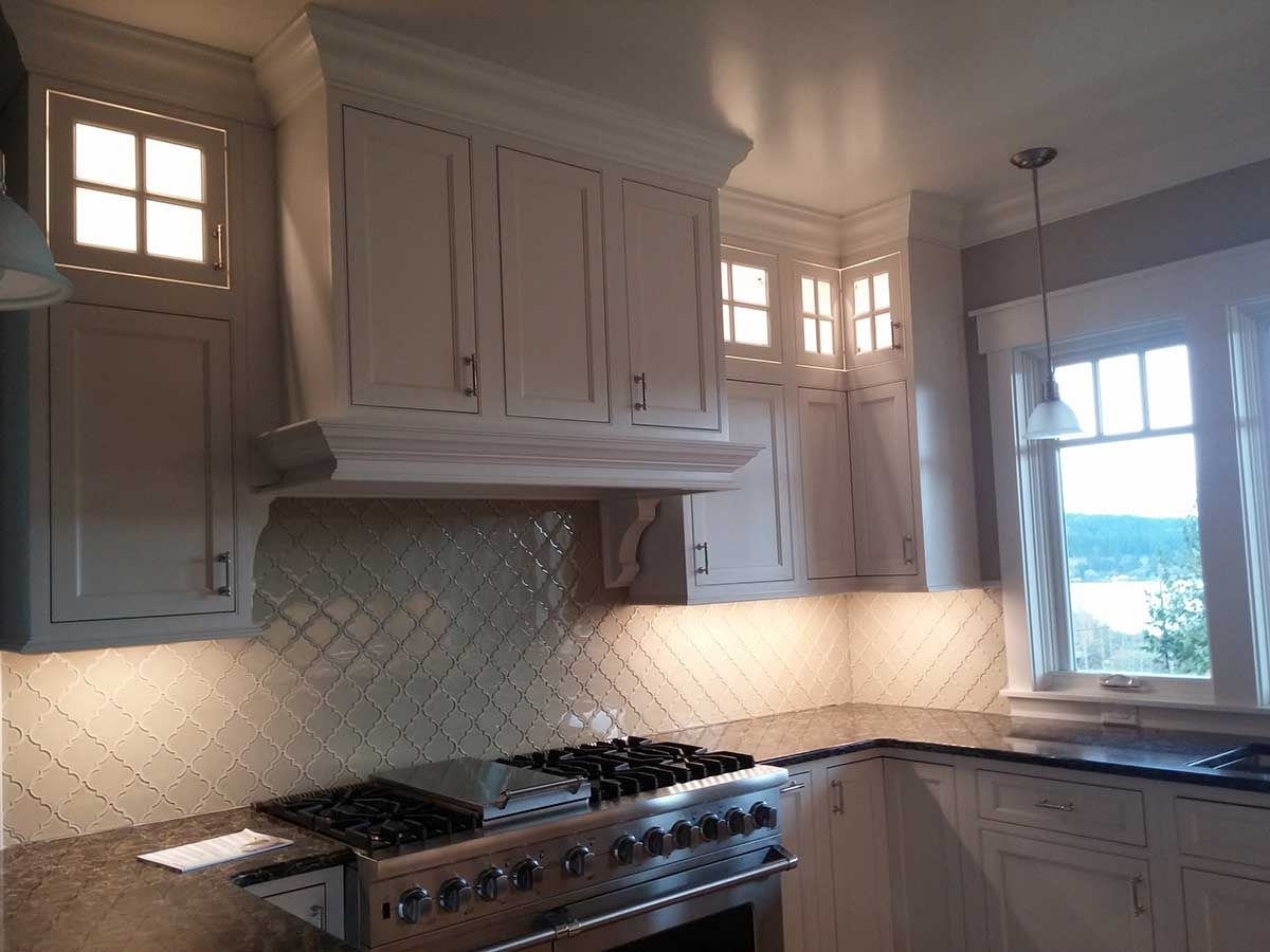 A kitchen with white cabinets and a stove top oven