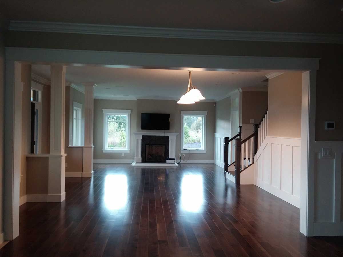 An empty living room with hardwood floors and a fireplace