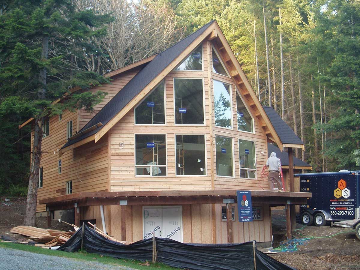 A large wooden house is being built in the woods
