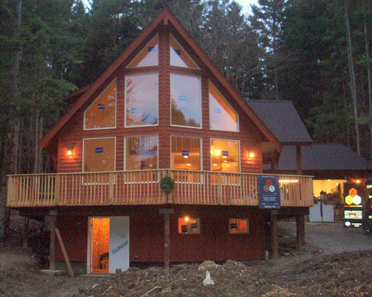 A large house with a lot of windows is lit up at night