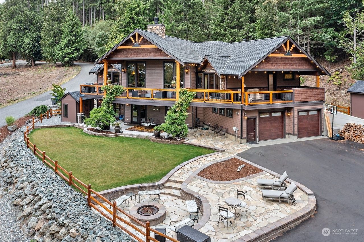 An aerial view of a large house with a fire pit in the backyard.